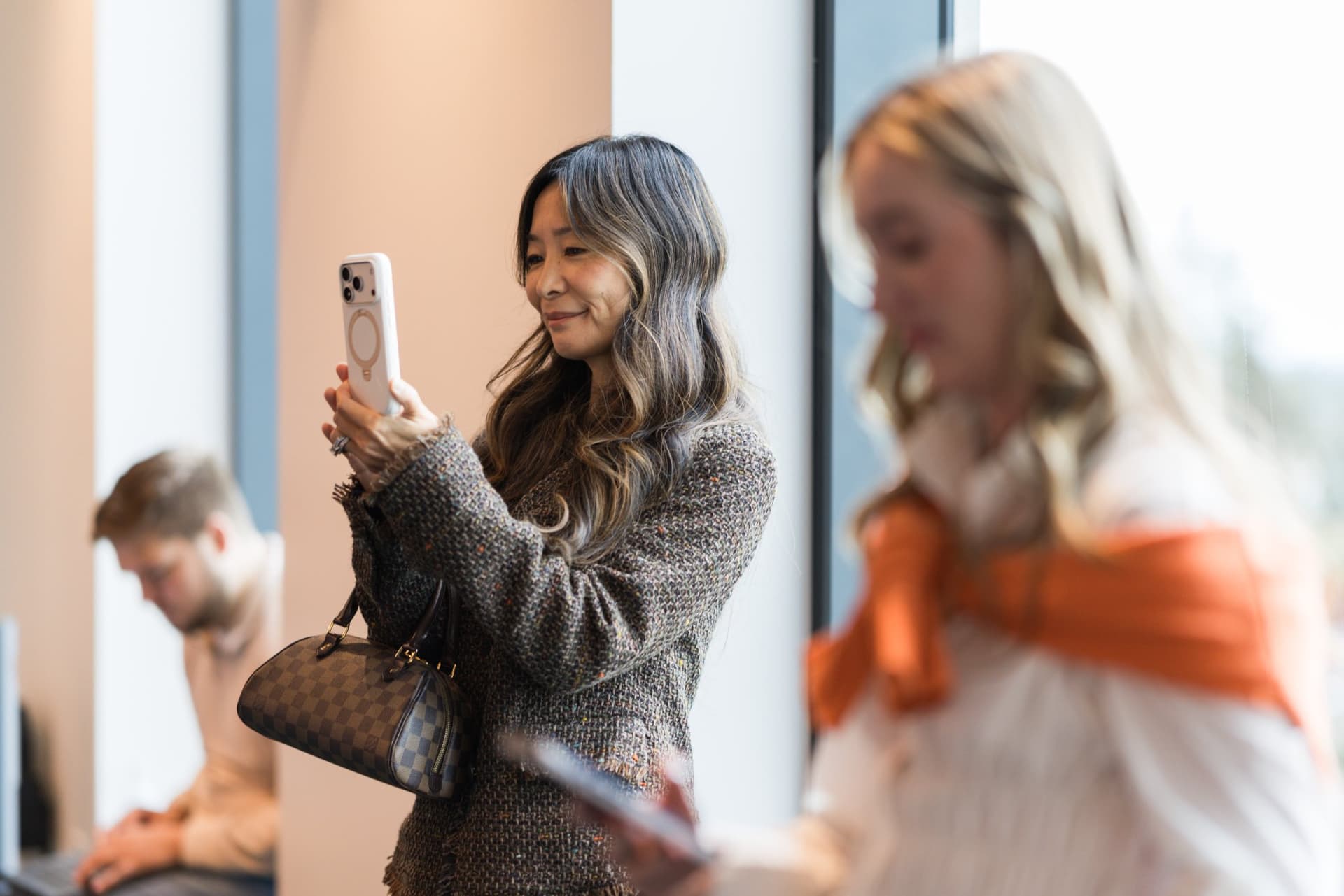 Attendee taking a photo of the stage with her phone at the PwC x 49ers event at PwC Silicon Valley in San Jose by JY Studio