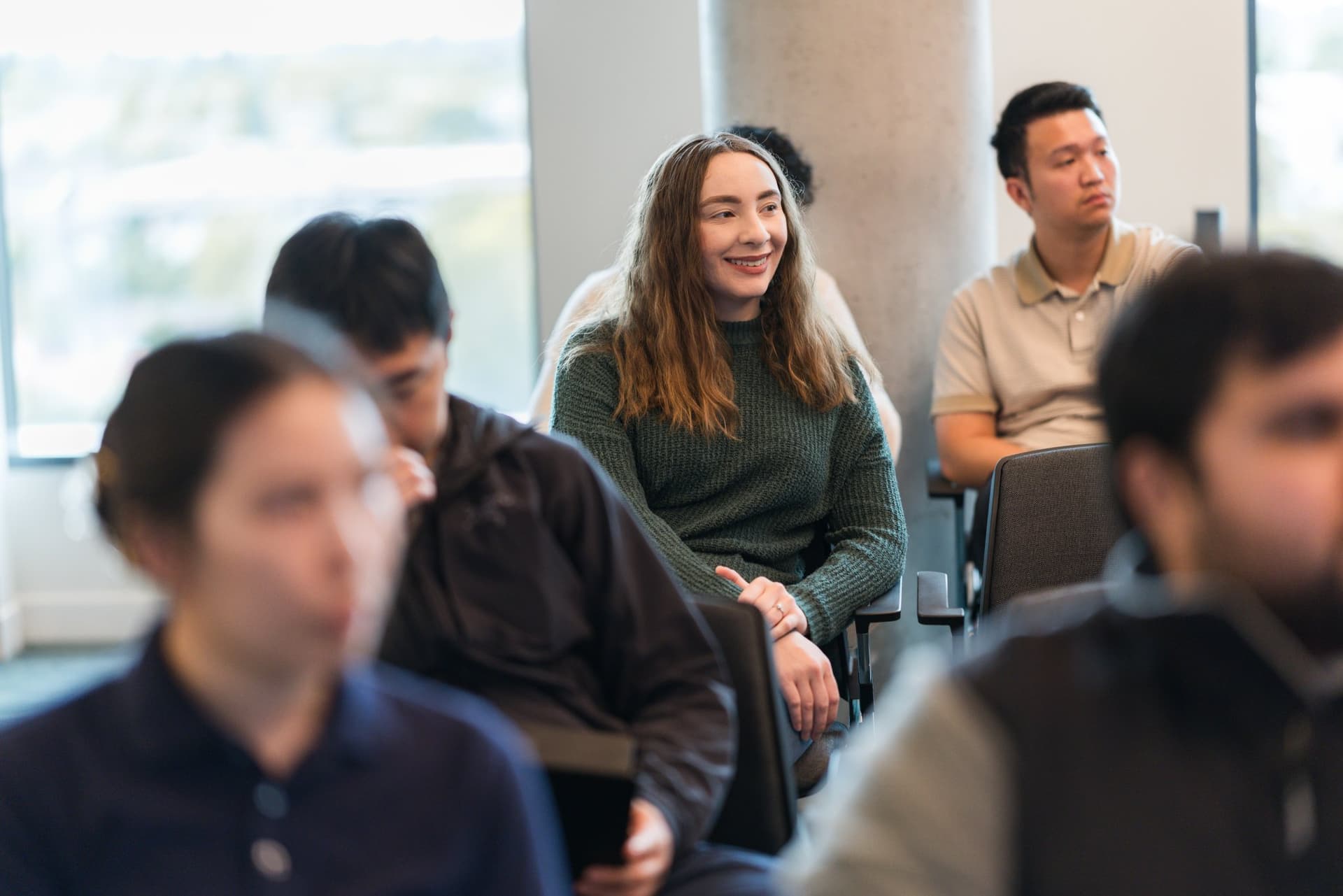 Attendee smiling while listening to the fireside chat at the PwC x 49ers event at PwC Silicon Valley in San Jose by JY Studio