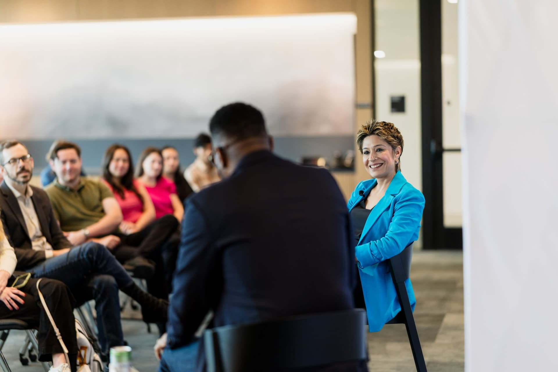Moderator smiling at the 49ers legend with the audience behind at the PwC x 49ers event at PwC Silicon Valley in San Jose by JY Studio
