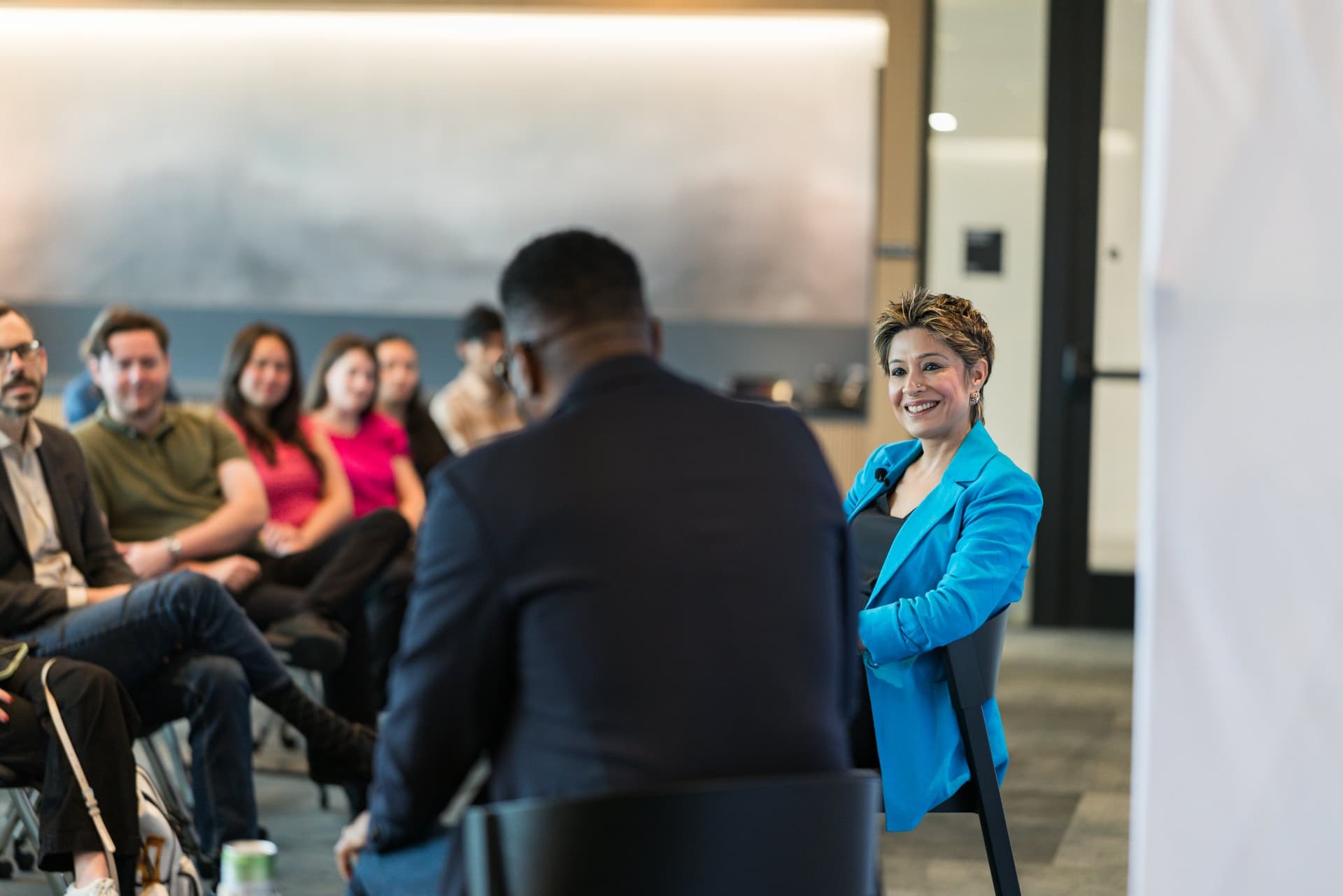 Moderator laughing during the fireside chat as attendees look on at the PwC x 49ers event at PwC Silicon Valley in San Jose by JY Studio