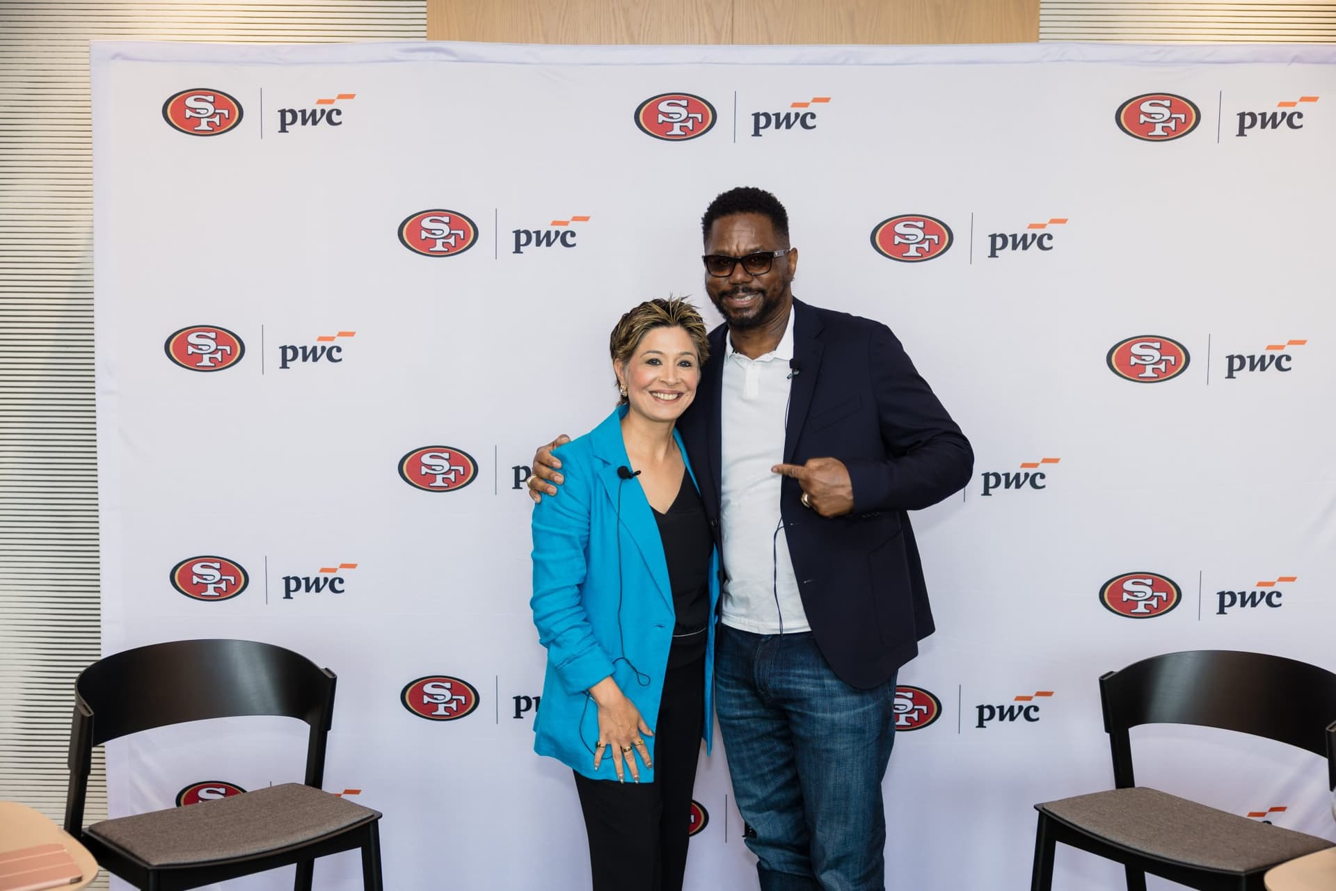 Moderator and 49ers legend posing at the step-and-repeat at the PwC x 49ers event at PwC Silicon Valley in San Jose by JY Studio