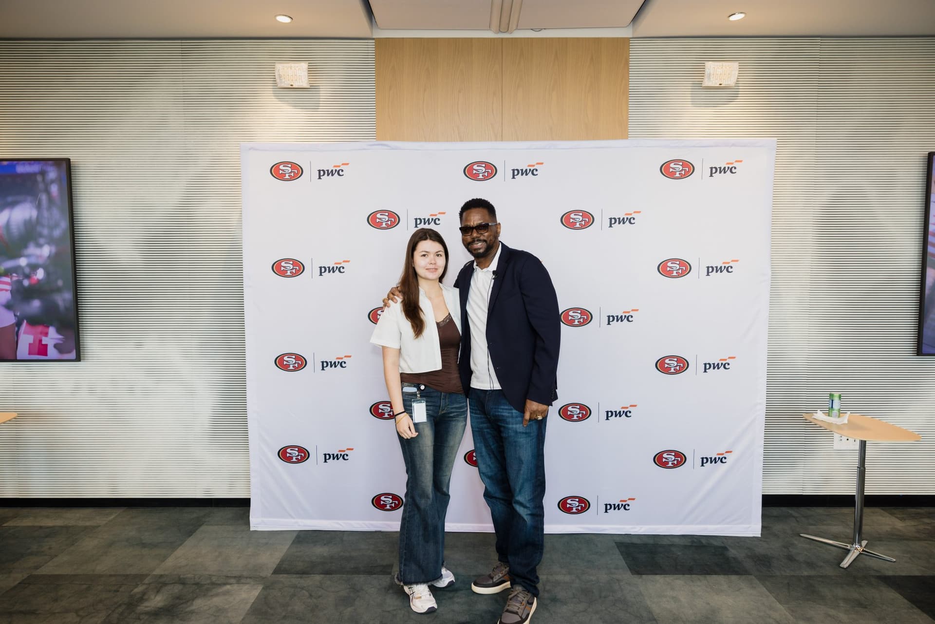 Attendee posing with the 49ers legend at the step-and-repeat at the PwC x 49ers event at PwC Silicon Valley in San Jose by JY Studio