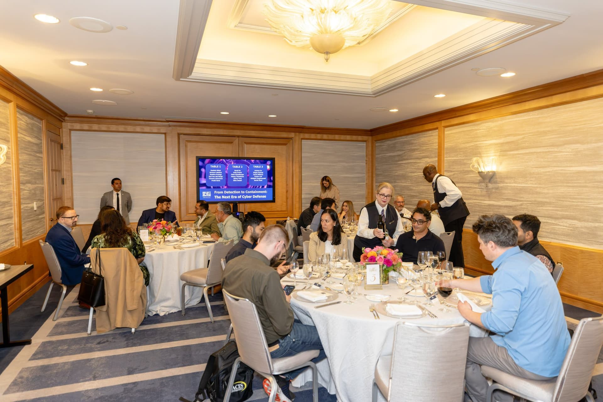 Attendees seated at the elegantly set dinner table during the Select World Services executive dinner in San Francisco