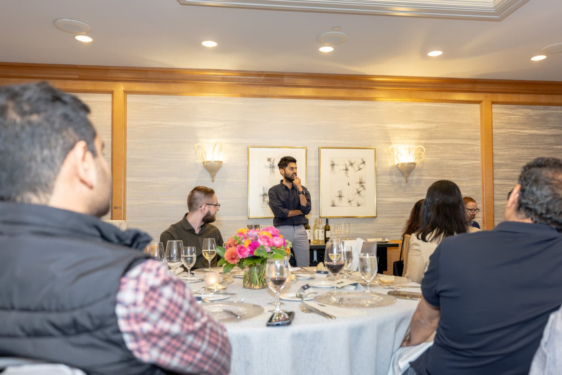 Attendee smiling while listening to dinner conversation at the Select World Services event in San Francisco