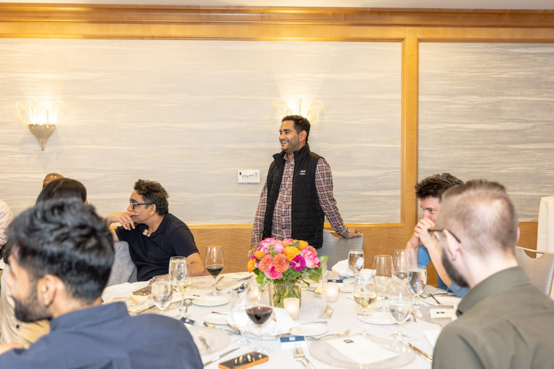 Guest standing to share remarks with the table during the Select World Services executive dinner in San Francisco