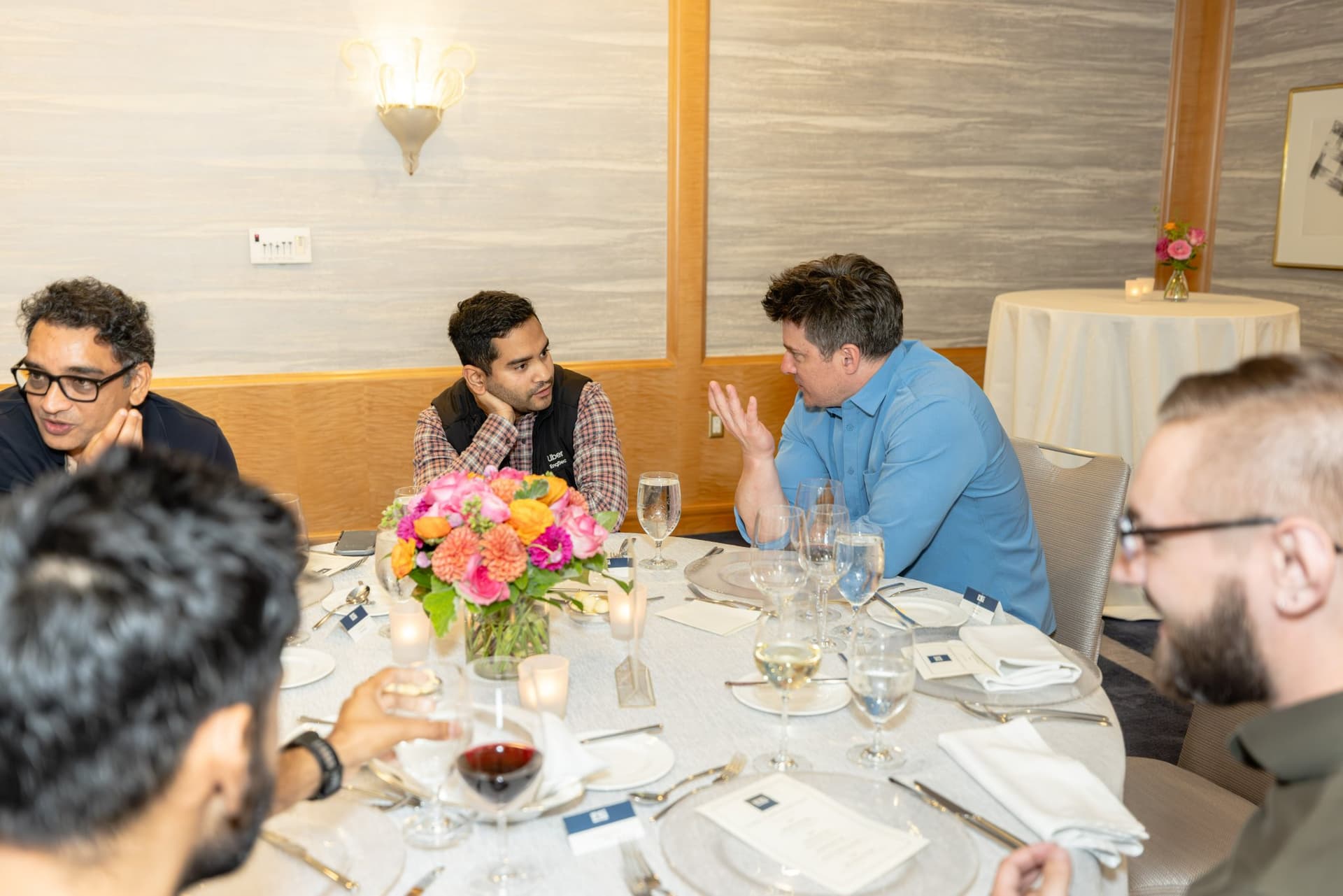 Speaker gesturing while presenting on cyber defense strategy at the Select World Services executive dinner in San Francisco