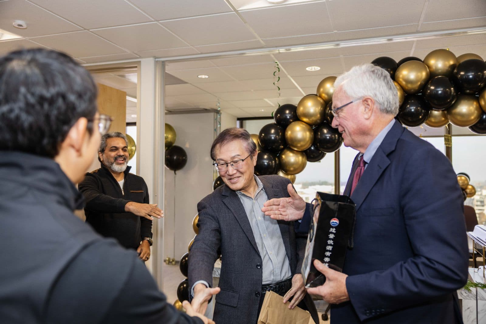 Heartfelt candid moment of colleagues celebrating at a retirement party in San Mateo by JY Studio