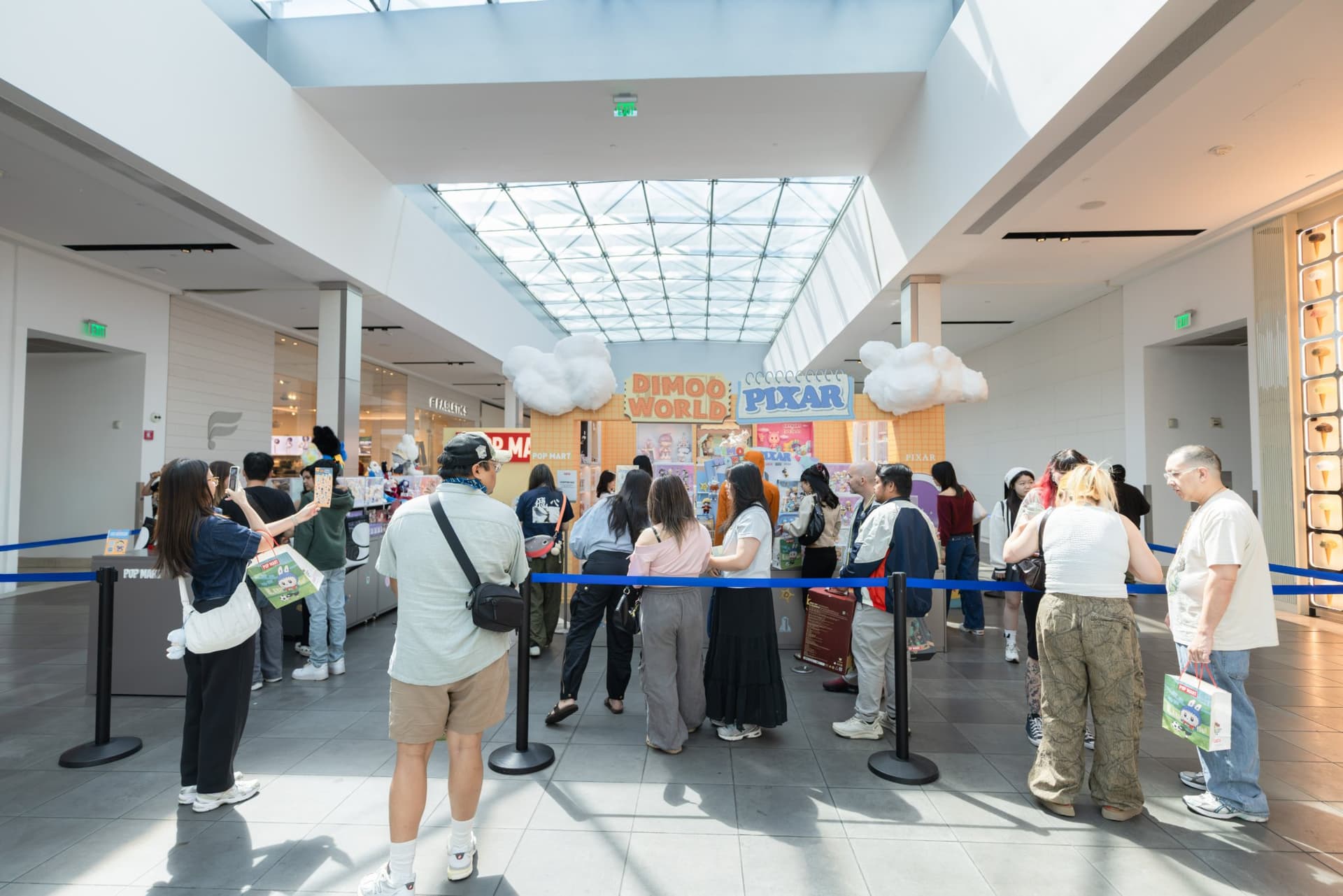 Collectors lining up along the stanchions for the DIMOO creator Ayan signing at the Pop Mart DIMOO signing event at Westfield Valley Fair in Santa Clara by JY Studio