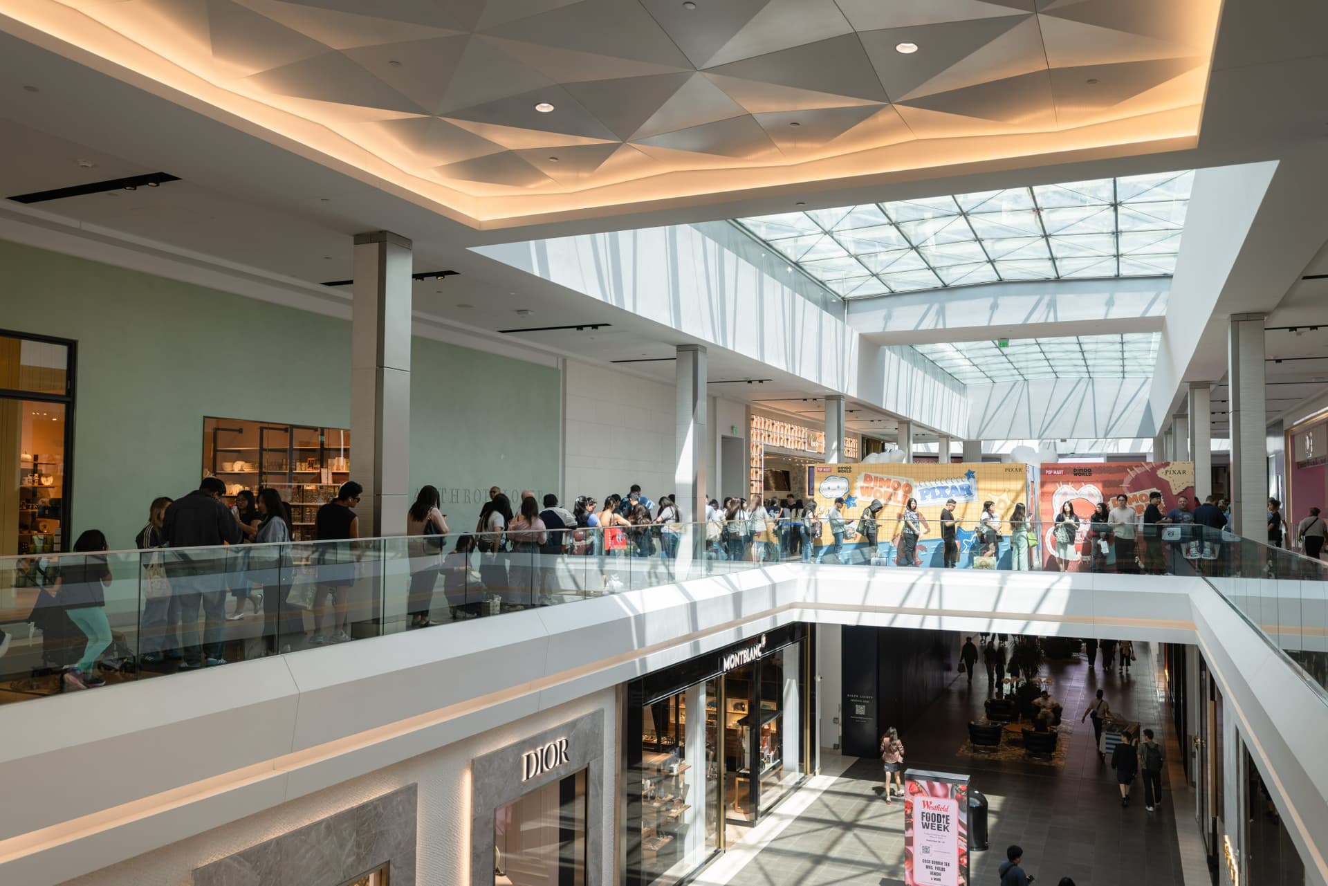 Long line of DIMOO collectors stretching along the upper level of Westfield Valley Fair mall at the Pop Mart DIMOO signing event at Westfield Valley Fair in Santa Clara by JY Studio