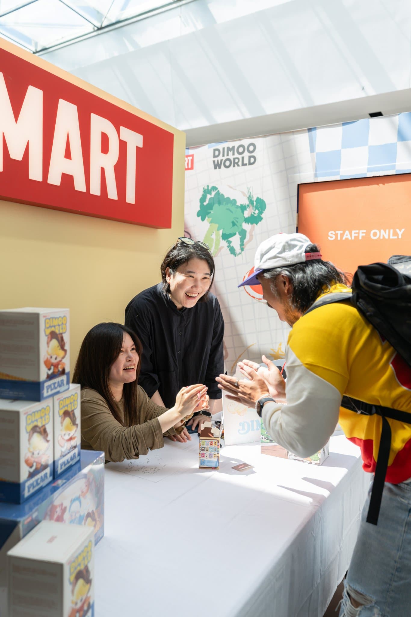 Fans laughing with DIMOO creator Ayan during the signing at the Pop Mart DIMOO signing event at Westfield Valley Fair in Santa Clara by JY Studio