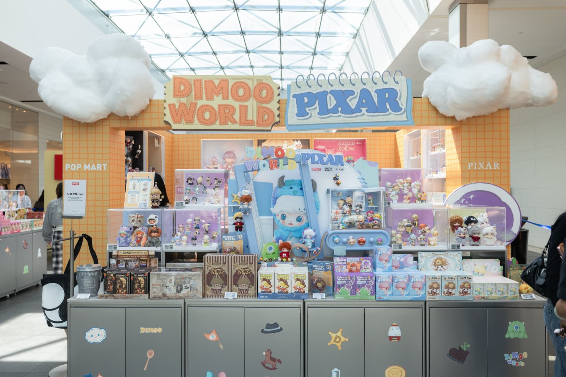 DIMOO WORLD x PIXAR pop-up booth with cloud decorations under the Valley Fair skylight at the Pop Mart DIMOO WORLD x PIXAR pop-up at Westfield Valley Fair in Santa Clara by JY Studio