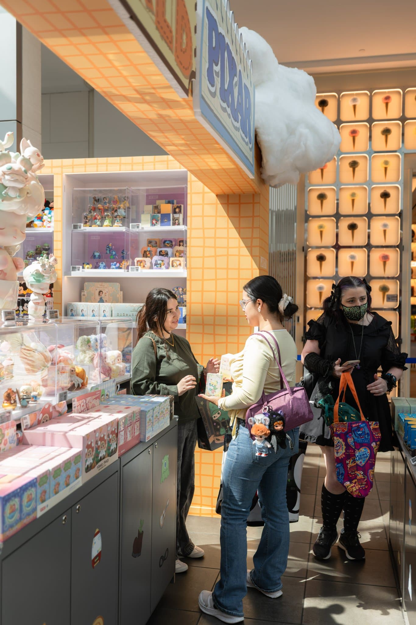 Collectors shopping at the DIMOO WORLD pop-up shelves at the Pop Mart DIMOO WORLD x PIXAR pop-up at Westfield Valley Fair in Santa Clara by JY Studio