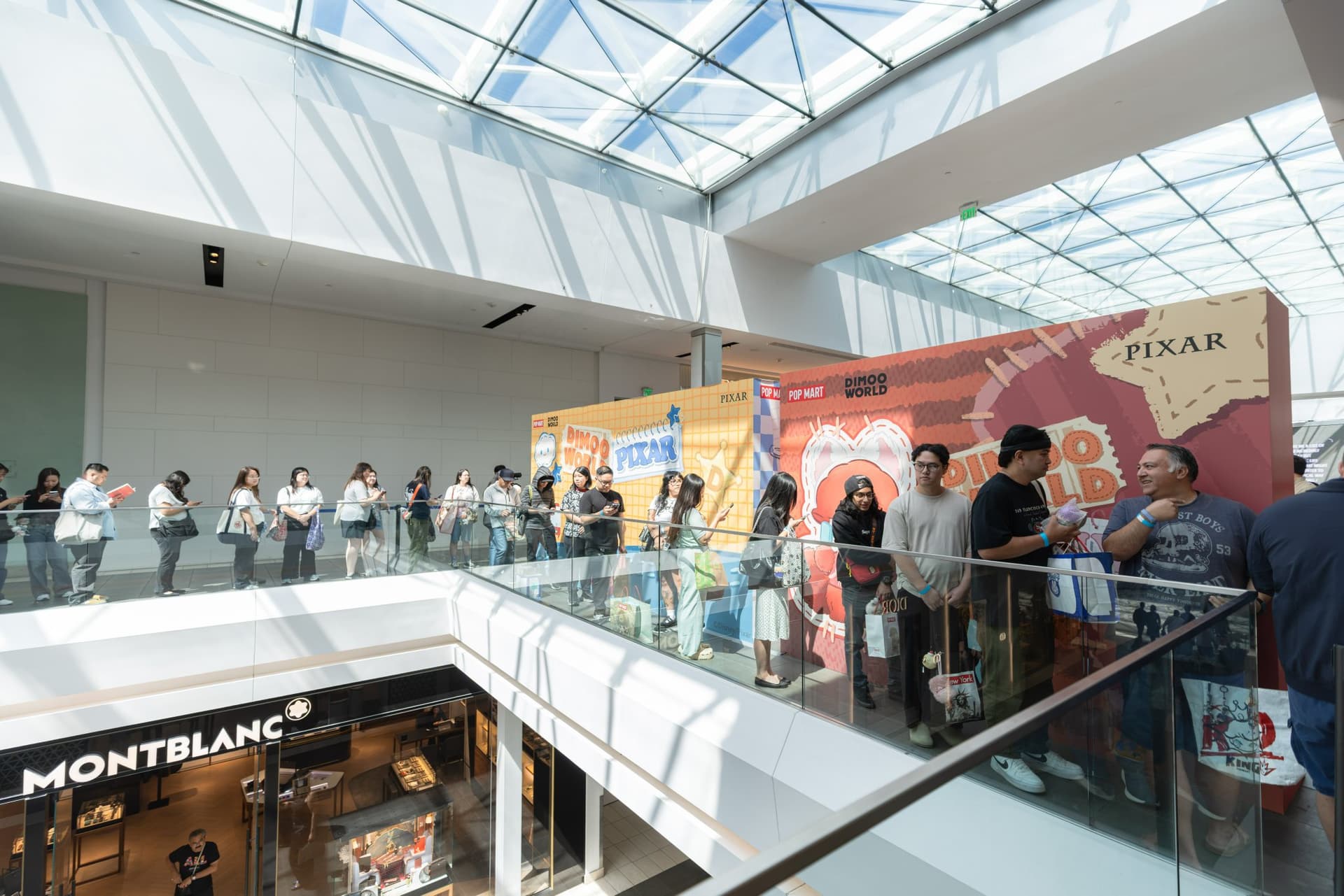 Line of Pop Mart fans along the second-floor railing above Montblanc at Westfield Valley Fair at the Pop Mart DIMOO signing event at Westfield Valley Fair in Santa Clara by JY Studio