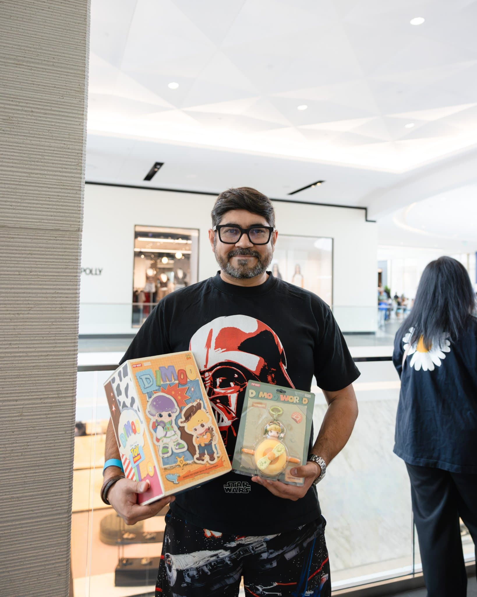 Fan holding DIMOO x PIXAR boxes signed by Ayan at the Pop Mart DIMOO signing event at Westfield Valley Fair in Santa Clara by JY Studio