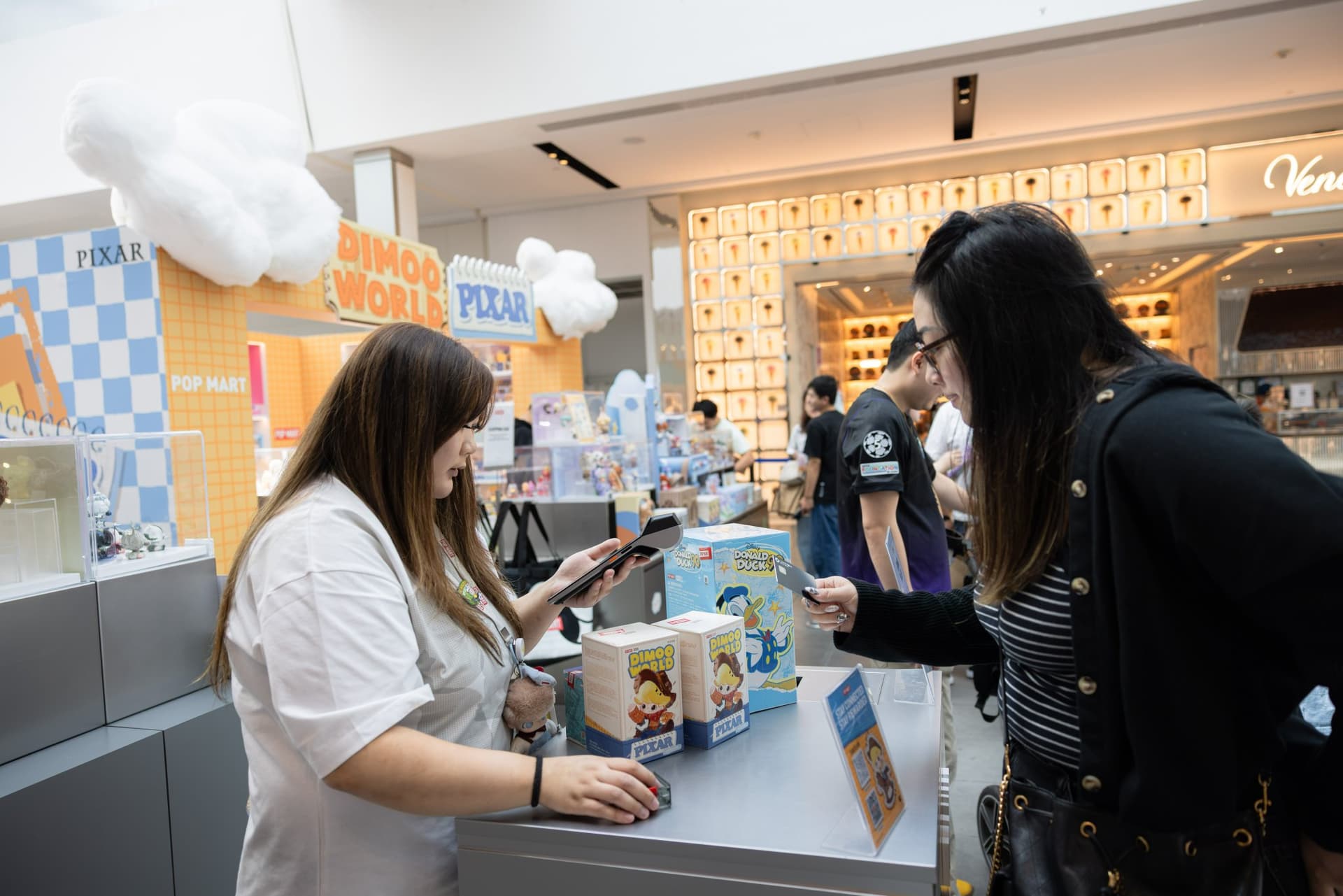 Fans picking DIMOO x PIXAR blind boxes at the pop-up counter at the Pop Mart DIMOO WORLD x PIXAR pop-up at Westfield Valley Fair in Santa Clara by JY Studio