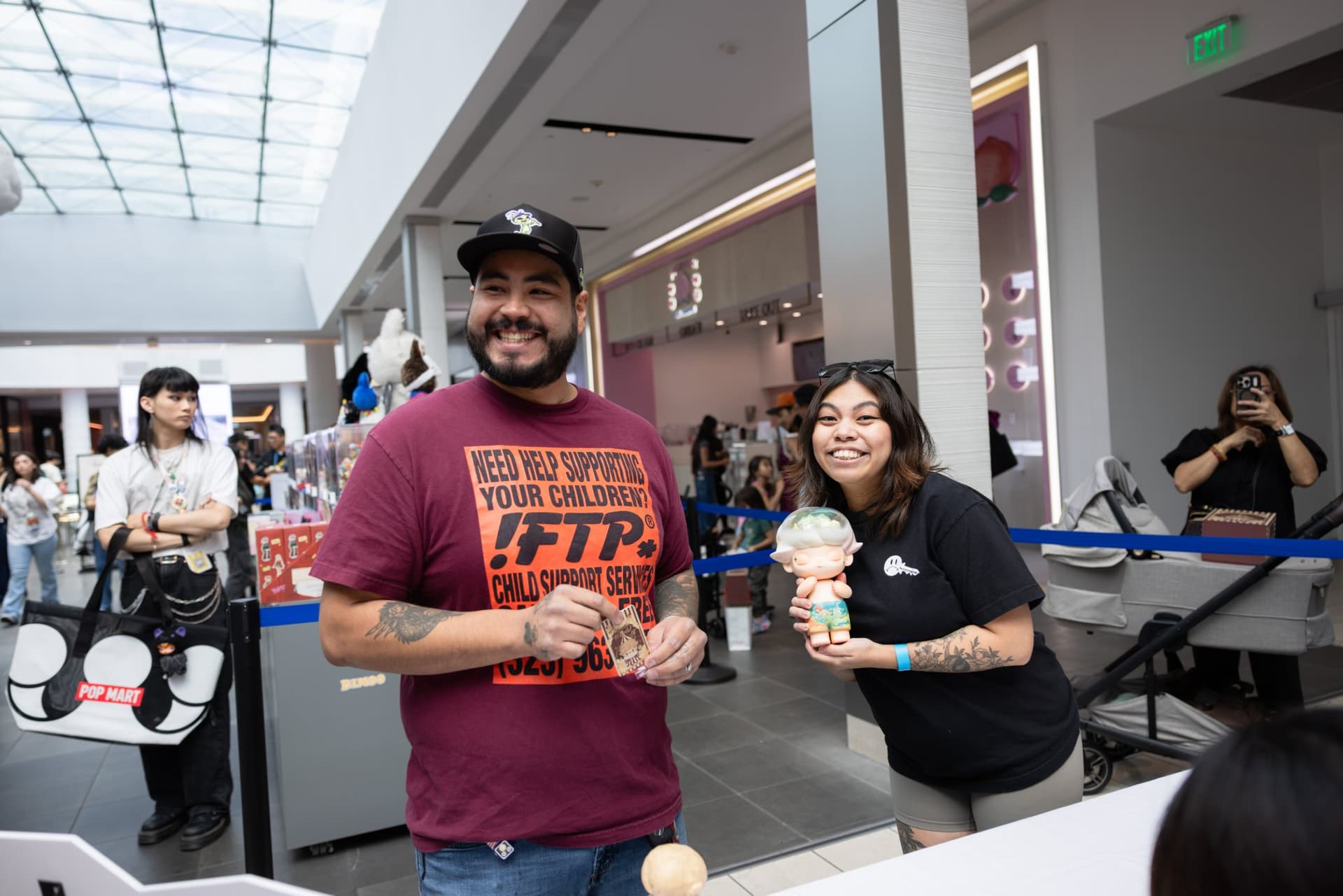 Fans posing with a signed DIMOO figure at the signing table at the Pop Mart DIMOO signing event at Westfield Valley Fair in Santa Clara by JY Studio