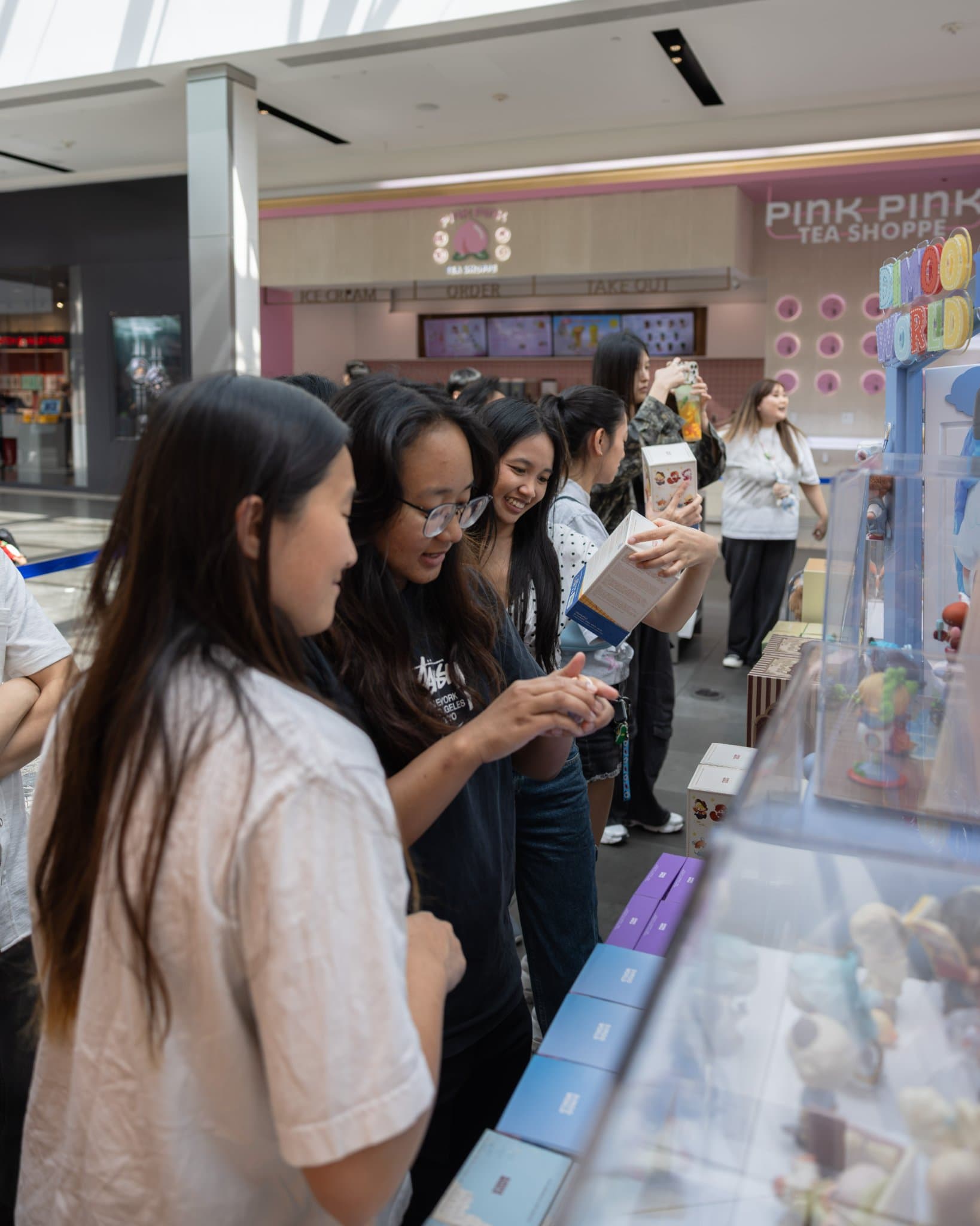 Young fans opening DIMOO blind boxes at the pop-up at the Pop Mart DIMOO WORLD x PIXAR pop-up at Westfield Valley Fair in Santa Clara by JY Studio