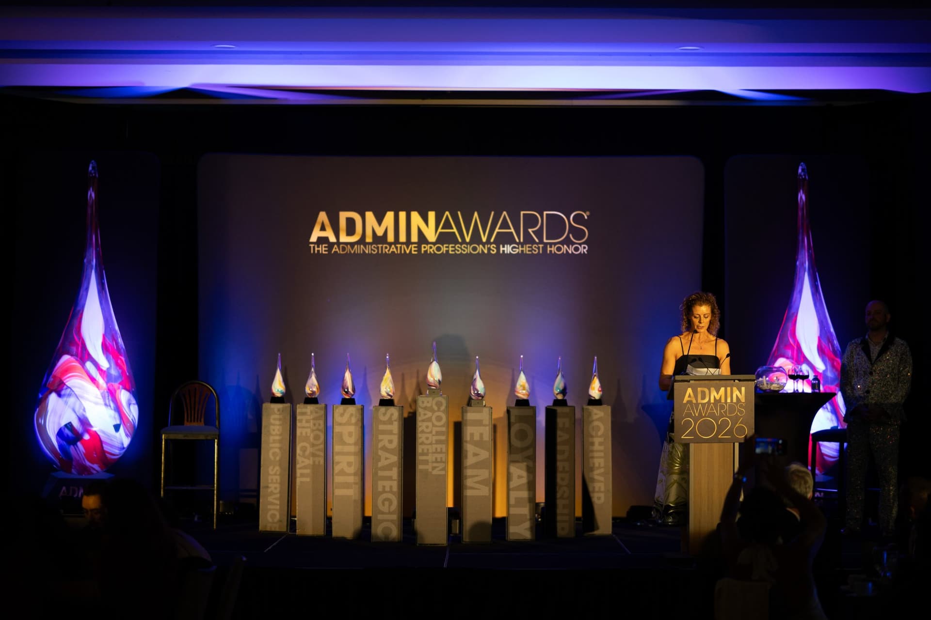 Wide view of the Admin Awards stage with glass teardrop trophies and award category pillars at Admin Awards 2026 at SFO Marriott Waterfront, Burlingame by JY Studio
