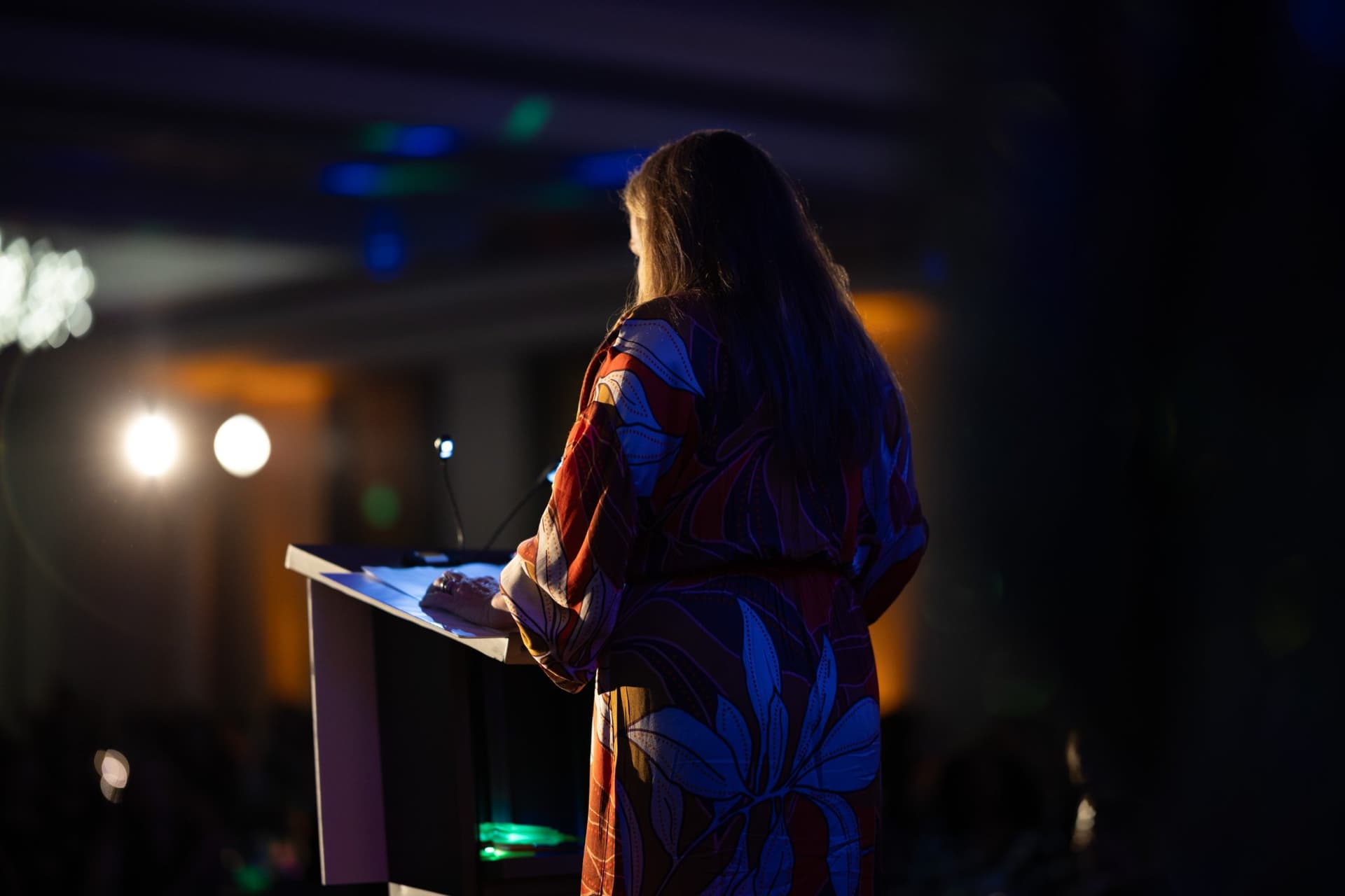 Speaker at the lectern facing the ballroom audience under stage spotlights at Admin Awards 2026 at SFO Marriott Waterfront, Burlingame by JY Studio