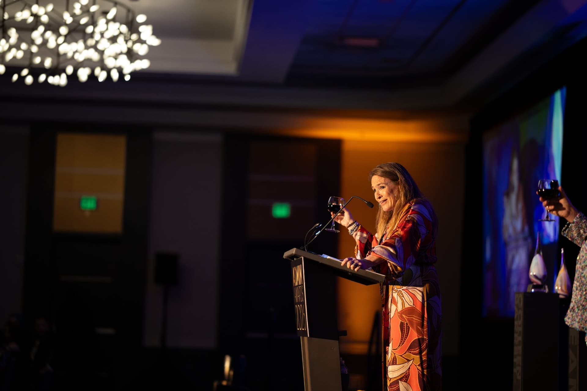 Speaker raising a glass for a toast from the podium at Admin Awards 2026 at SFO Marriott Waterfront, Burlingame by JY Studio