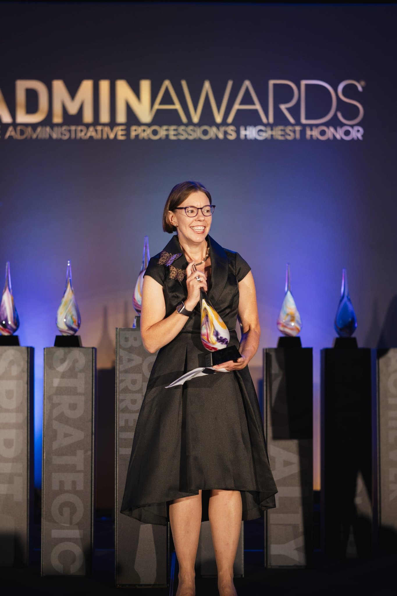Honoree holding her trophy while giving an acceptance speech at Admin Awards 2026 at SFO Marriott Waterfront, Burlingame by JY Studio