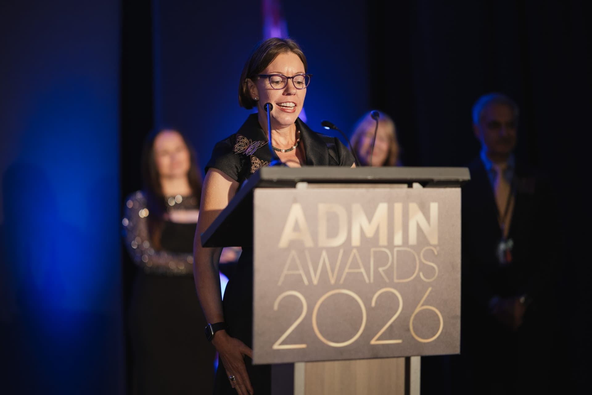 Honoree delivering an acceptance speech as colleagues look on at Admin Awards 2026 at SFO Marriott Waterfront, Burlingame by JY Studio