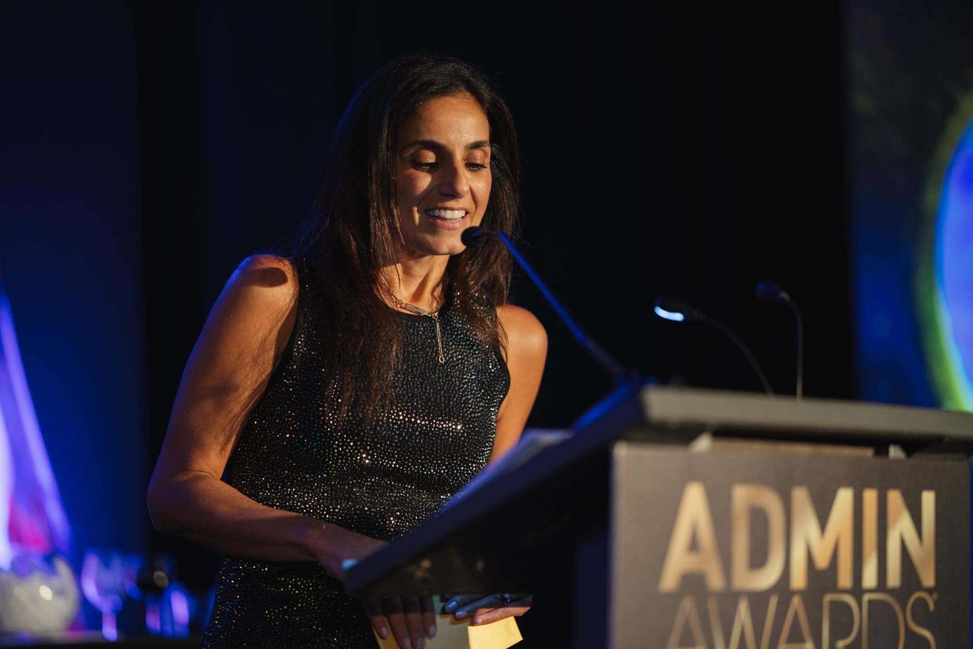 Honoree smiling while reading her acceptance speech at the podium at Admin Awards 2026 at SFO Marriott Waterfront, Burlingame by JY Studio