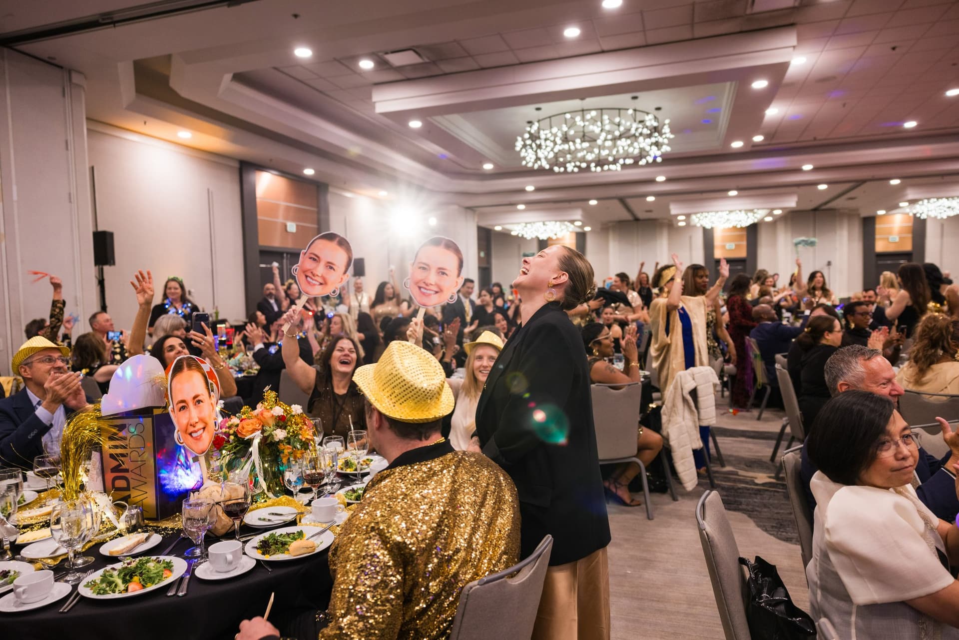 Guests cheering with oversized nominee face cutouts at their banquet table at Admin Awards 2026 at SFO Marriott Waterfront, Burlingame by JY Studio