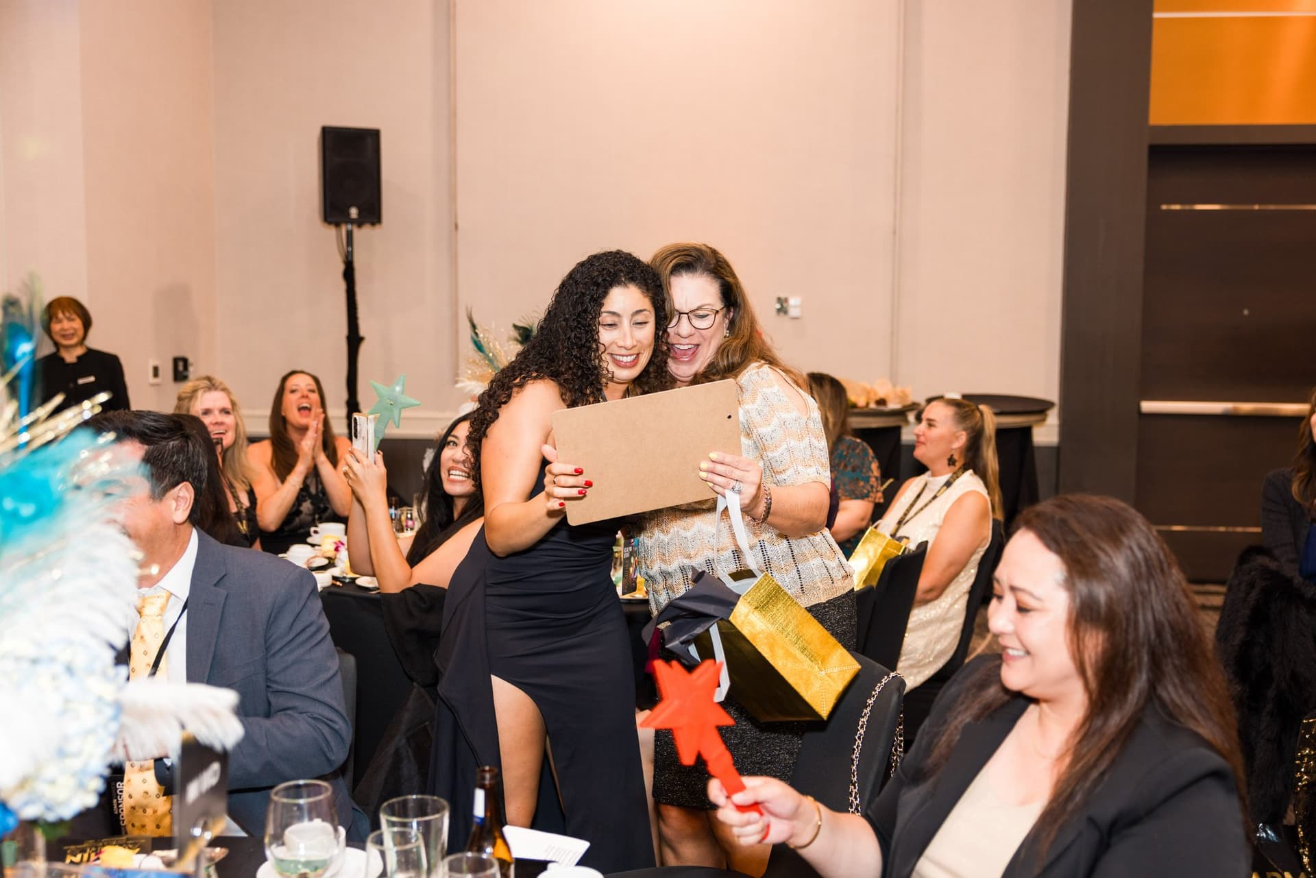 Guests hugging and celebrating at their banquet table during the ceremony at Admin Awards 2026 at SFO Marriott Waterfront, Burlingame by JY Studio