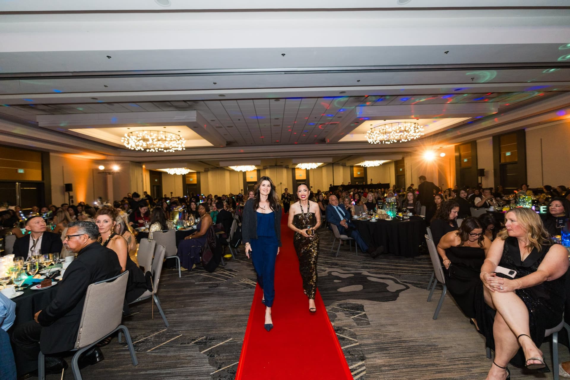 Honoree walking the red carpet aisle through the ballroom toward the stage at Admin Awards 2026 at SFO Marriott Waterfront, Burlingame by JY Studio