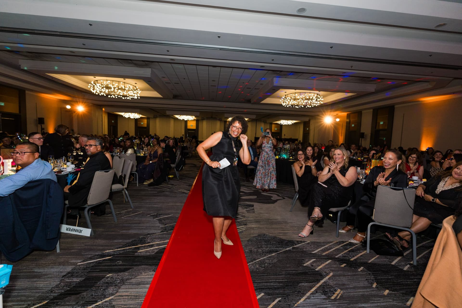 Honoree walking the red carpet as guests cheer from their tables at Admin Awards 2026 at SFO Marriott Waterfront, Burlingame by JY Studio