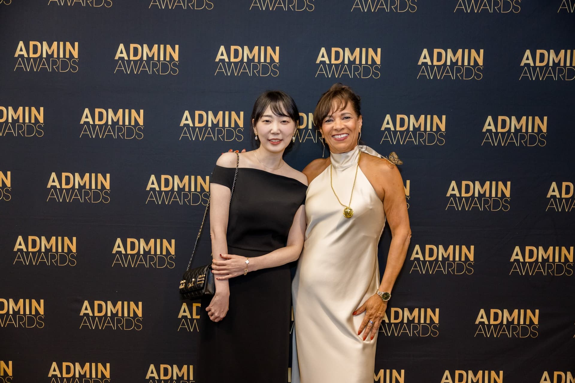 Two guests smiling together at the Admin Awards step-and-repeat at Admin Awards 2026 at SFO Marriott Waterfront, Burlingame by JY Studio