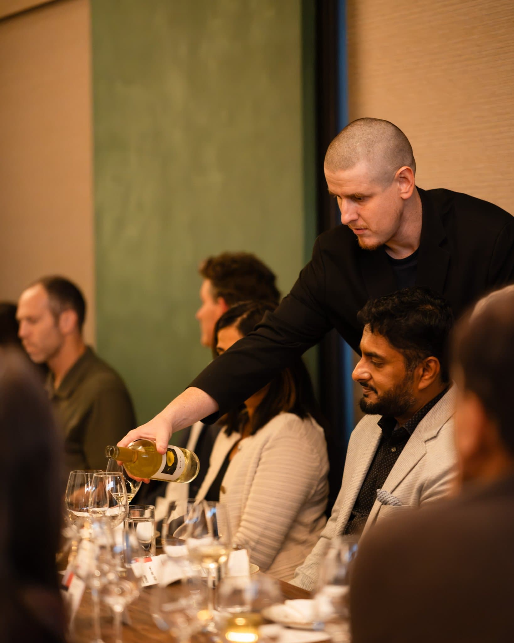 Server pouring white wine for executives at the dinner table at the Business Insider AI Insider executive dinner The Great Coding Reset during SF Tech Week 2026 in San Francisco by JY Studio