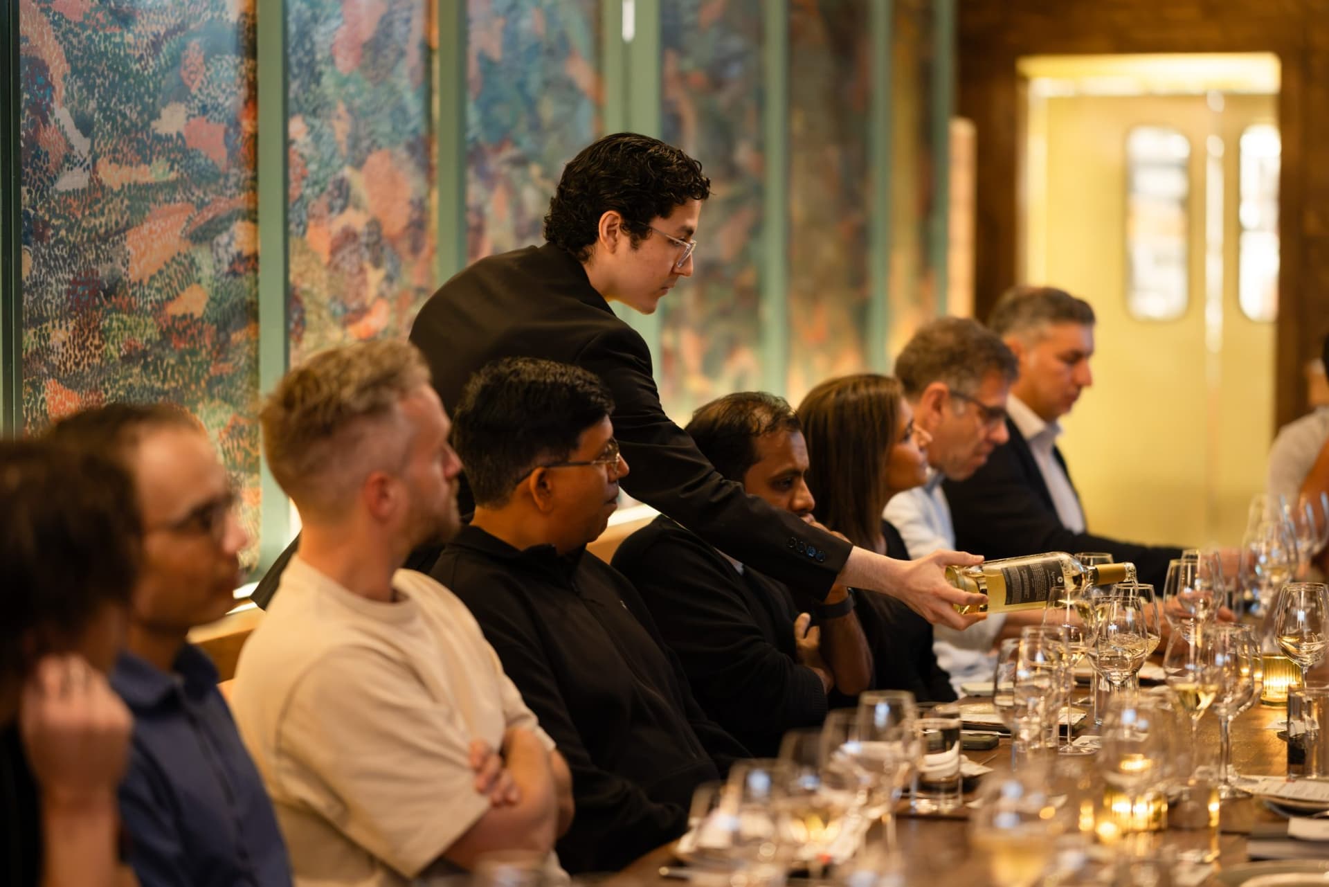 Server pouring wine as executives settle in for the roundtable at the Business Insider AI Insider executive dinner The Great Coding Reset during SF Tech Week 2026 in San Francisco by JY Studio