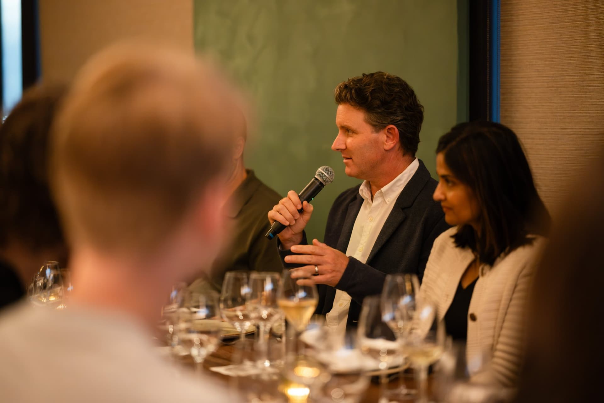 Tech executive speaking into a microphone at the dinner table at the Business Insider AI Insider executive dinner The Great Coding Reset during SF Tech Week 2026 in San Francisco by JY Studio