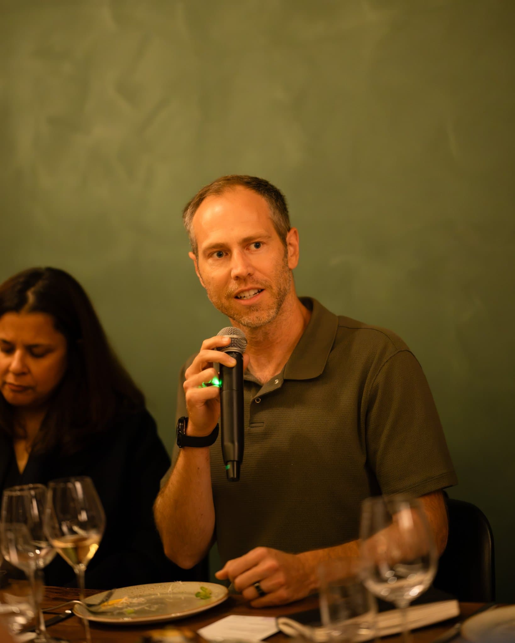 Engineering leader in an olive polo sharing a point with a microphone at the Business Insider AI Insider executive dinner The Great Coding Reset during SF Tech Week 2026 in San Francisco by JY Studio