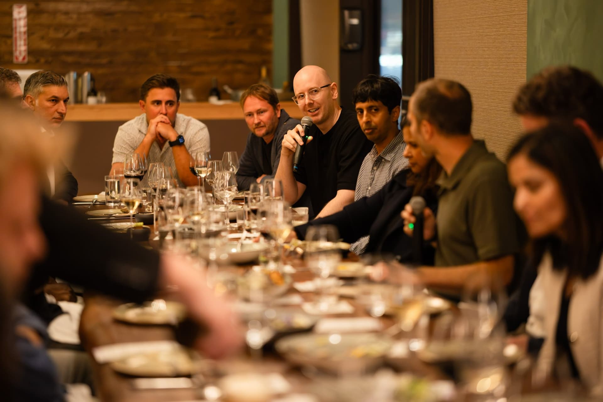 AI Insider host holding a microphone as executives discuss context for AI agents at the Business Insider AI Insider executive dinner The Great Coding Reset during SF Tech Week 2026 in San Francisco by JY Studio