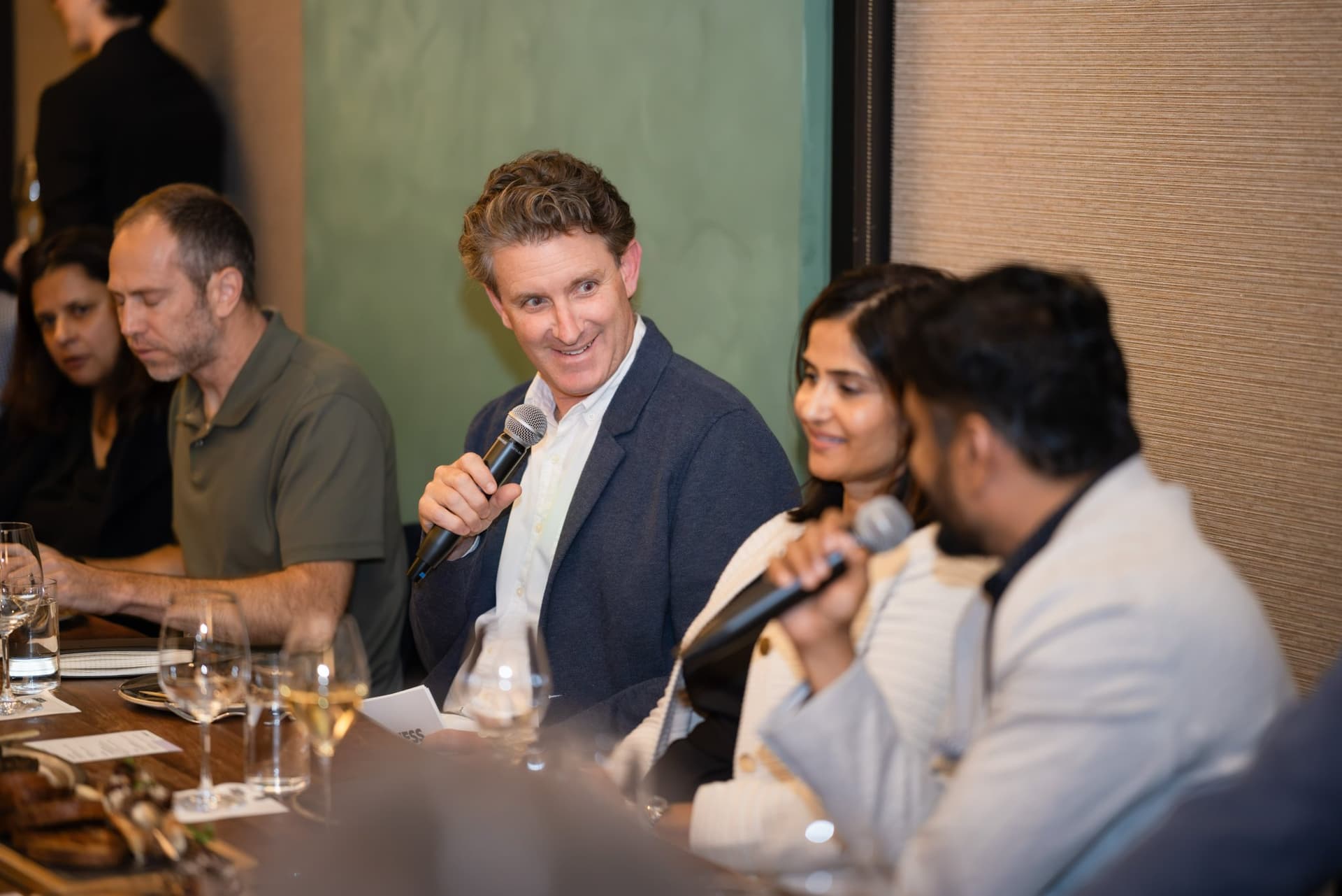 Executive smiling while speaking during the dinner roundtable at the Business Insider AI Insider executive dinner The Great Coding Reset during SF Tech Week 2026 in San Francisco by JY Studio
