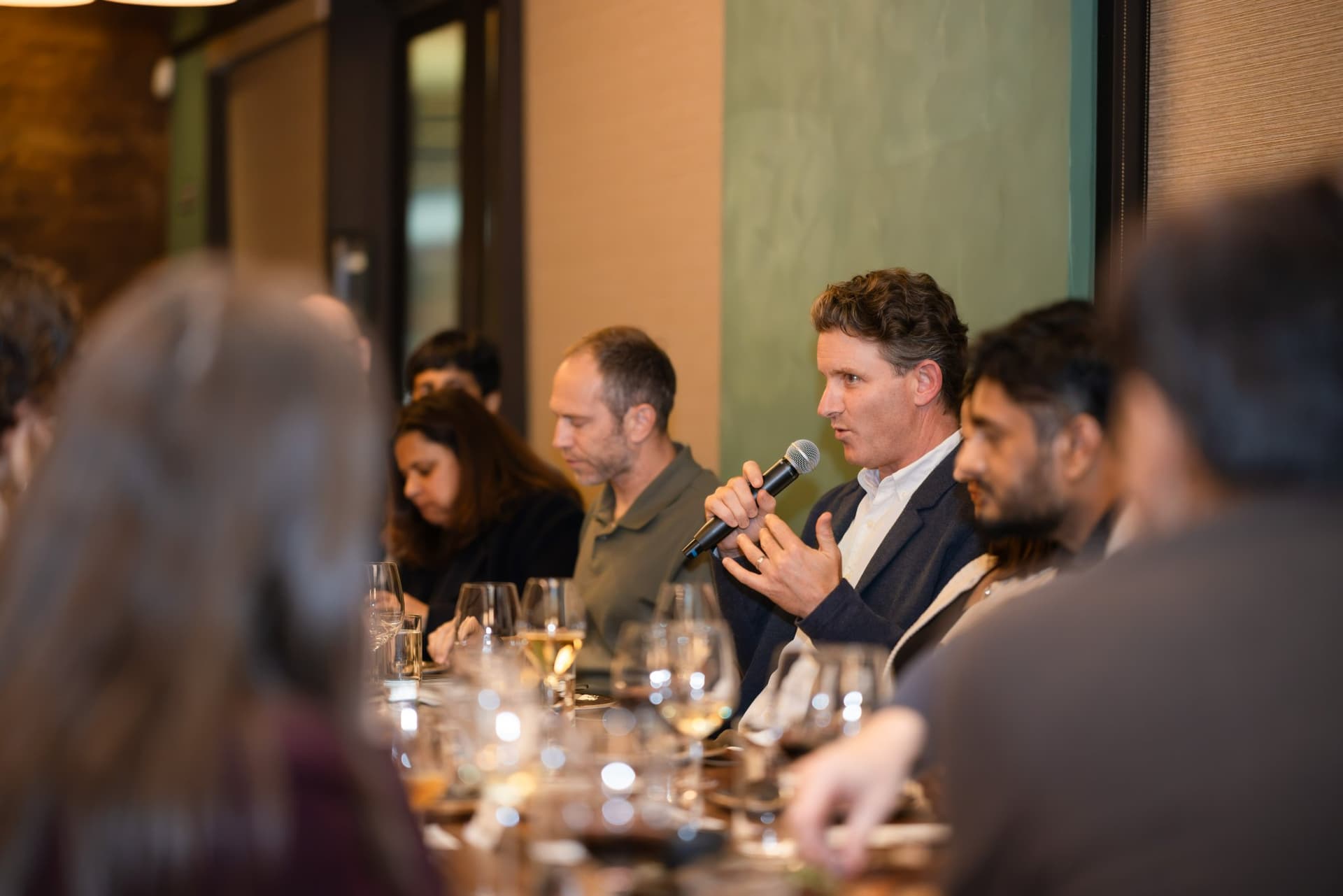 Tech leader making a point with a microphone over dinner at the Business Insider AI Insider executive dinner The Great Coding Reset during SF Tech Week 2026 in San Francisco by JY Studio