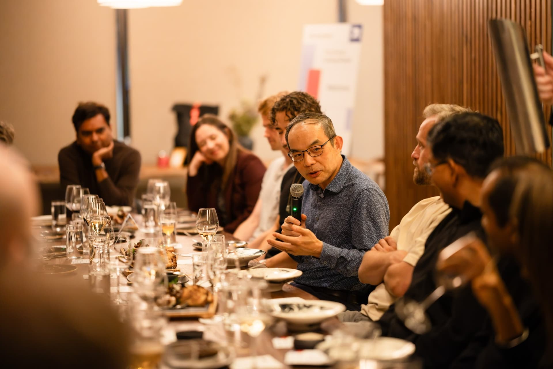 Executive in a blue shirt speaking about AI and software engineering at the Business Insider AI Insider executive dinner The Great Coding Reset during SF Tech Week 2026 in San Francisco by JY Studio