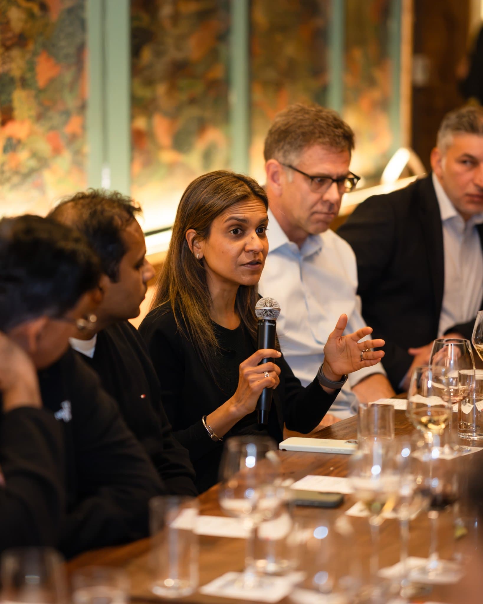 Woman tech executive speaking with a microphone at the dinner at the Business Insider AI Insider executive dinner The Great Coding Reset during SF Tech Week 2026 in San Francisco by JY Studio