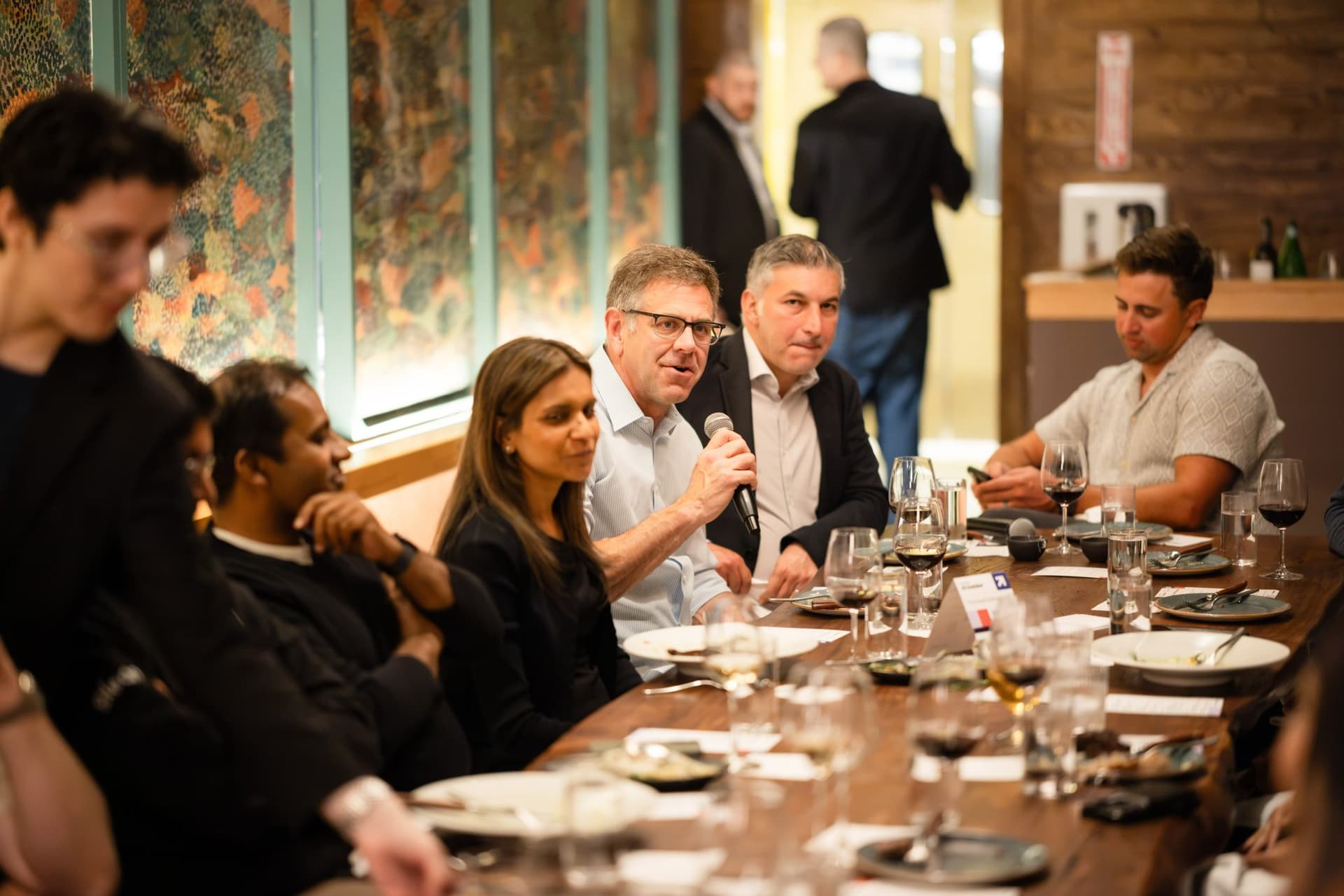 Executive speaking as tablemates listen at the Business Insider AI Insider executive dinner The Great Coding Reset during SF Tech Week 2026 in San Francisco by JY Studio