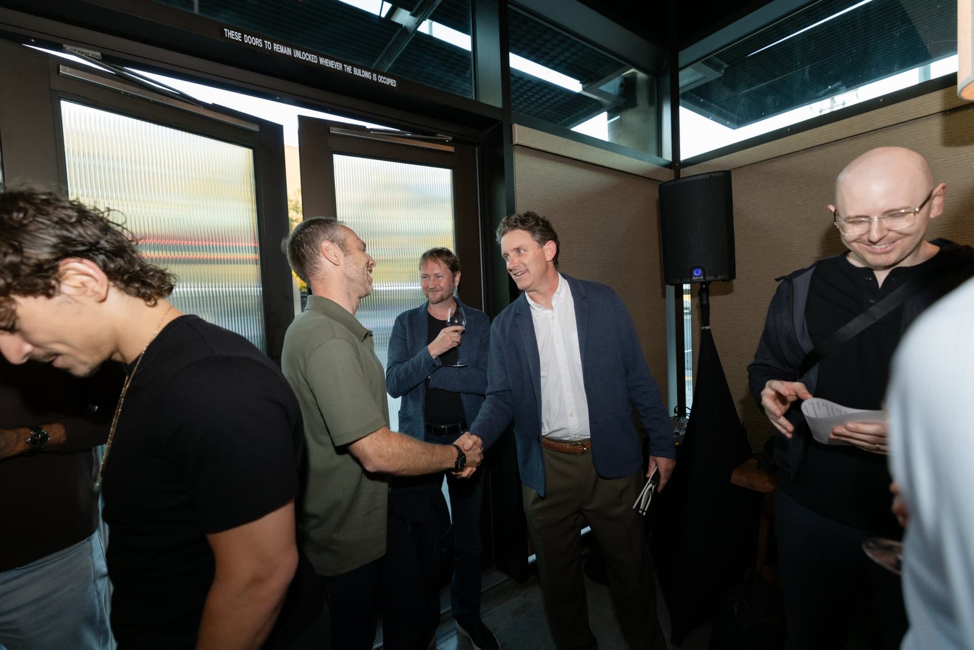 Executives greeting each other with handshakes at the entrance at the Business Insider AI Insider executive dinner The Great Coding Reset during SF Tech Week 2026 in San Francisco by JY Studio