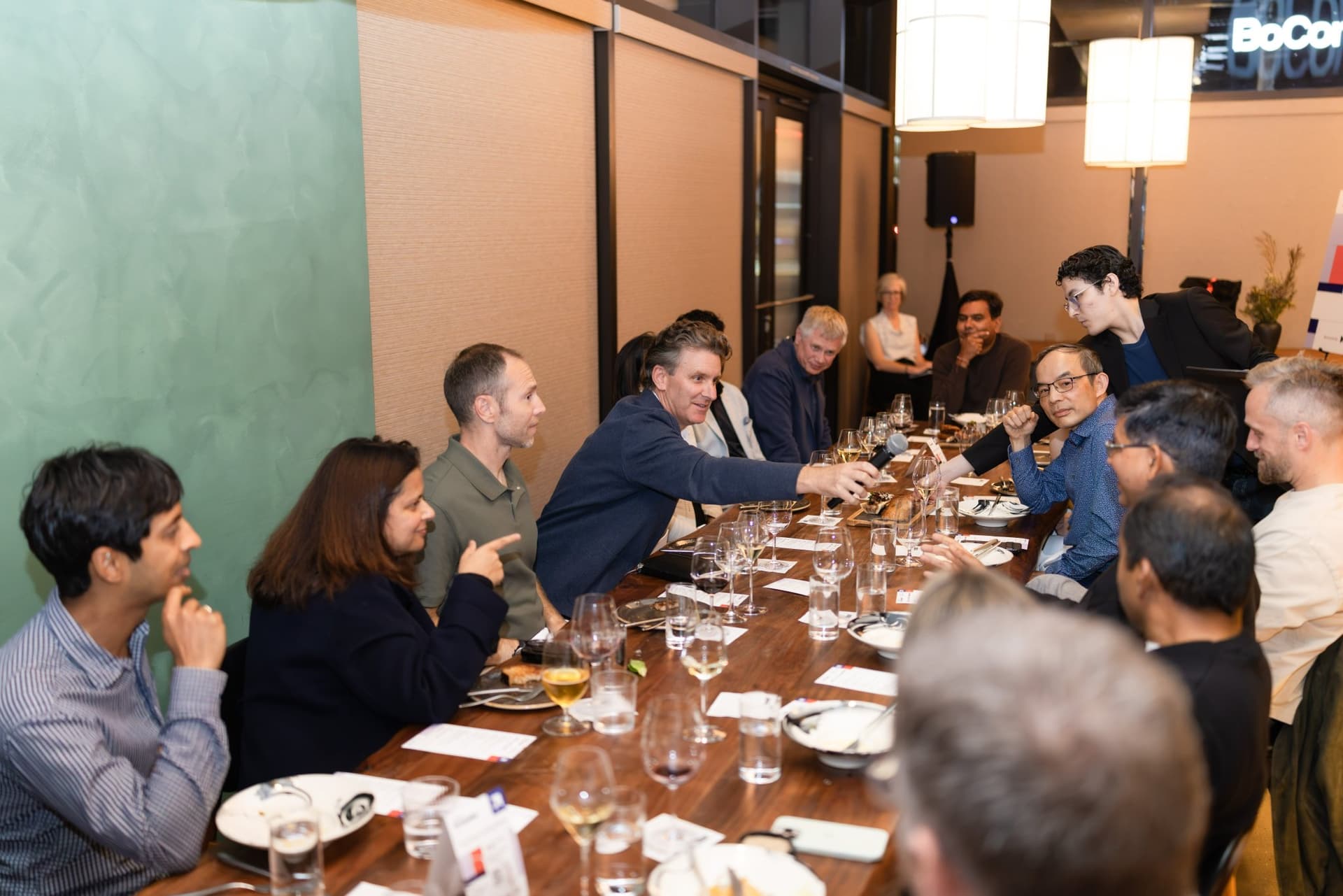 Executives pointing and debating across the long table at the Business Insider AI Insider executive dinner The Great Coding Reset during SF Tech Week 2026 in San Francisco by JY Studio