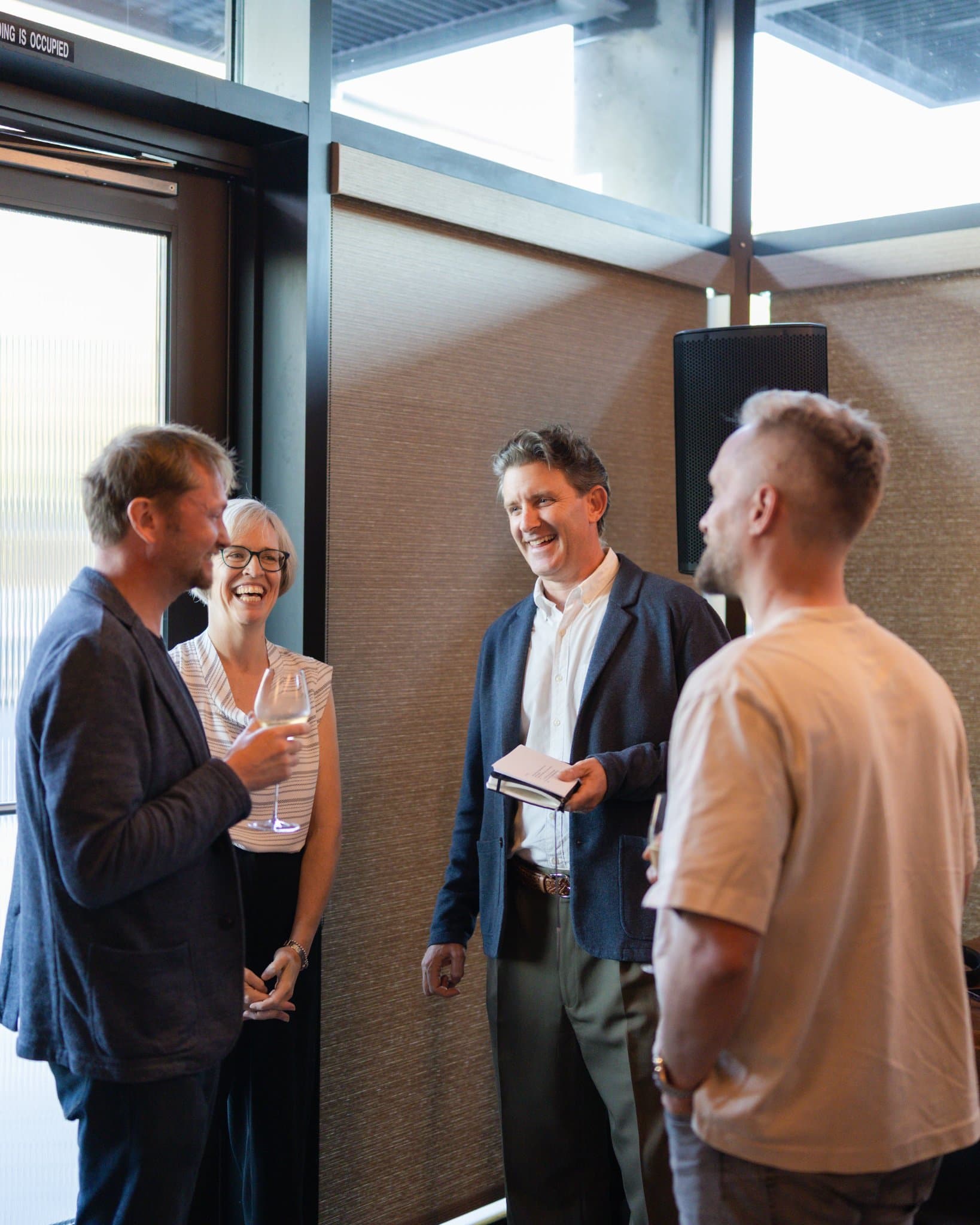 Executives laughing over drinks during the reception at the Business Insider AI Insider executive dinner The Great Coding Reset during SF Tech Week 2026 in San Francisco by JY Studio