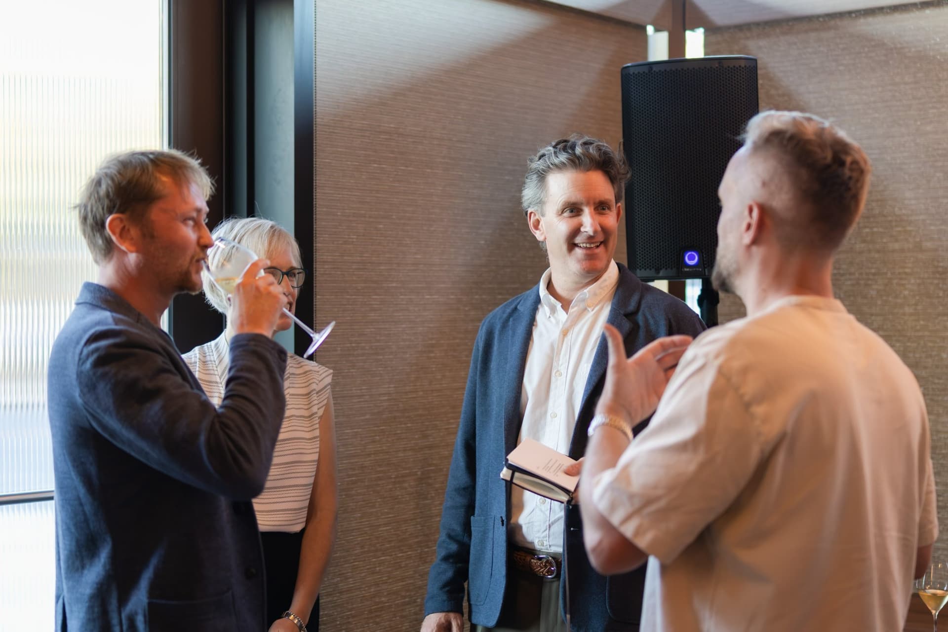 Executives chatting by the windows during the reception at the Business Insider AI Insider executive dinner The Great Coding Reset during SF Tech Week 2026 in San Francisco by JY Studio