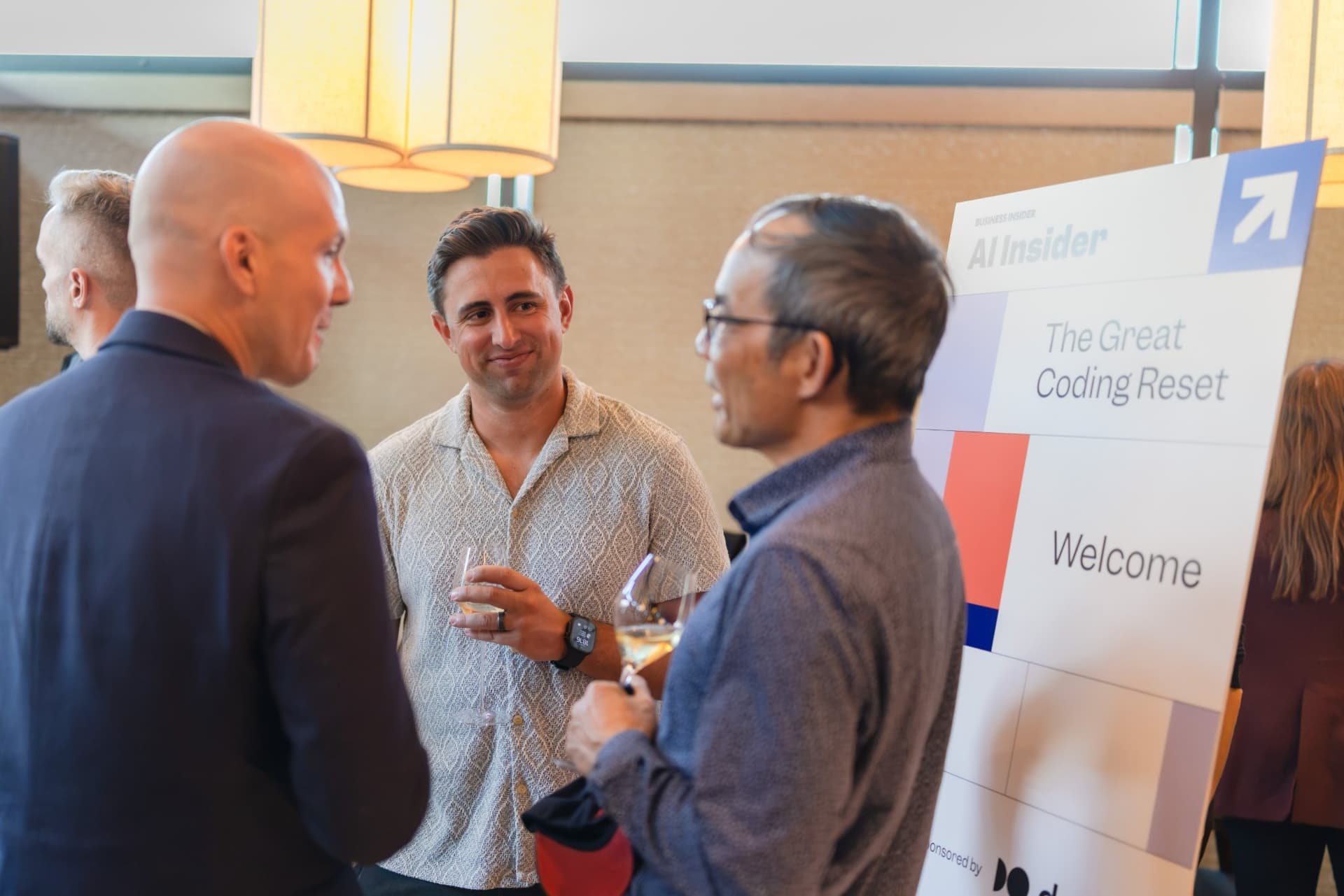 Guests talking beside the AI Insider welcome sign at the Business Insider AI Insider executive dinner The Great Coding Reset during SF Tech Week 2026 in San Francisco by JY Studio