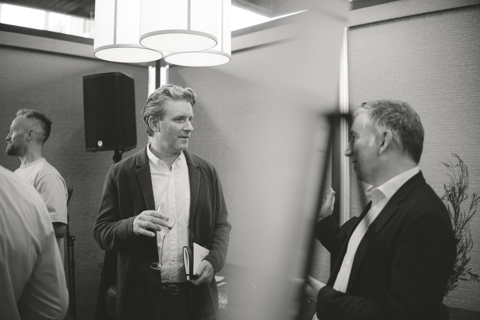 Black and white photo of two executives talking during the reception at the Business Insider AI Insider executive dinner The Great Coding Reset during SF Tech Week 2026 in San Francisco by JY Studio