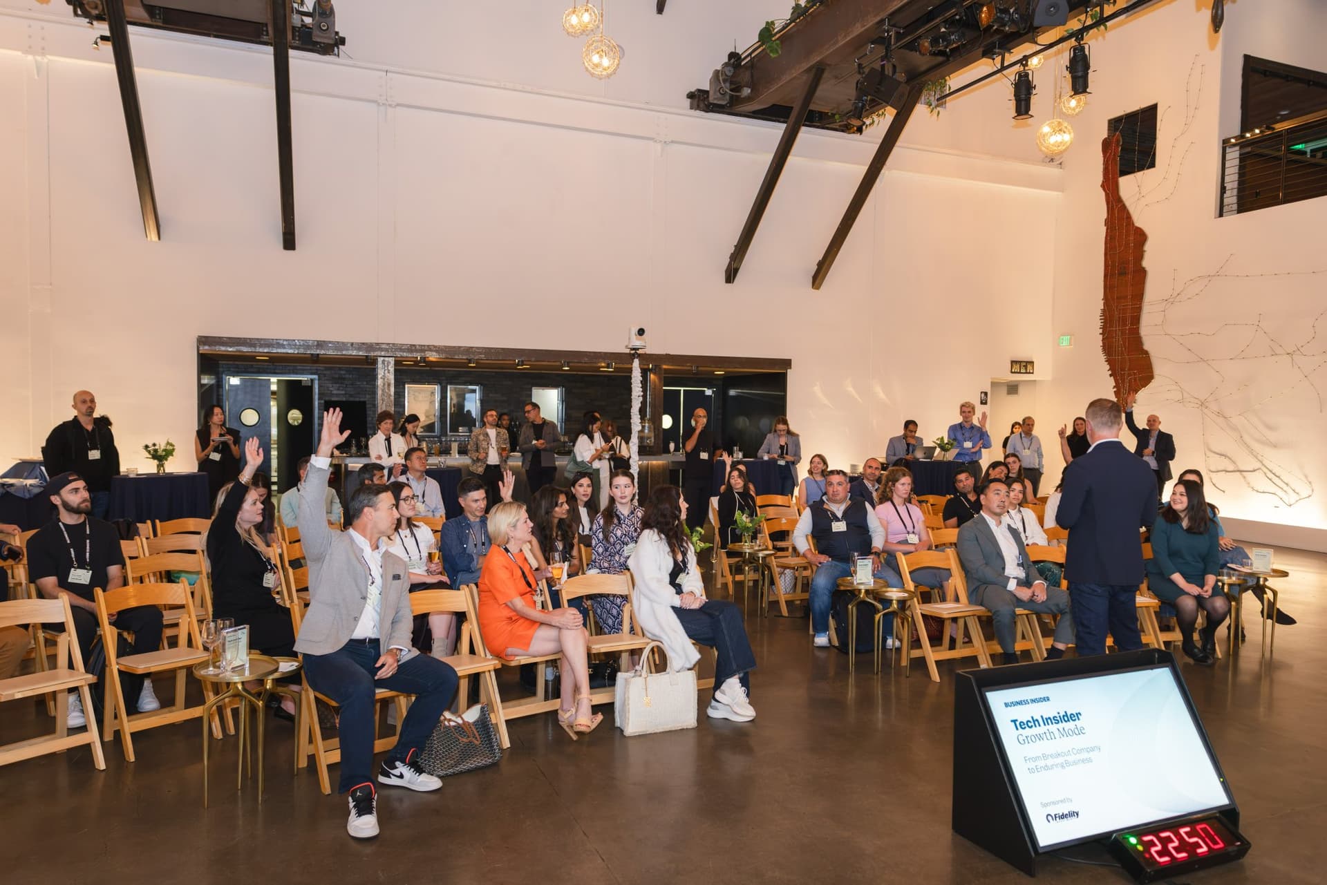 Attendees raising their hands during a poll at Business Insider Tech Insider: Growth Mode at The Pearl SF by JY Studio