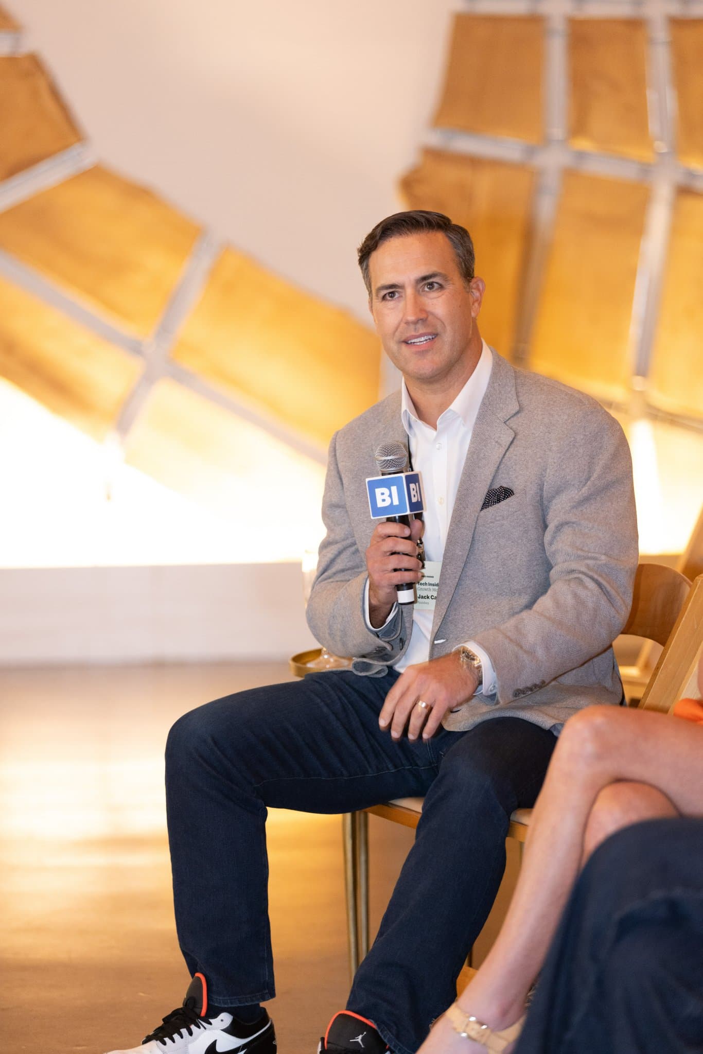 Attendee asking a question with a Business Insider microphone during the Town Hall at The Pearl SF by JY Studio